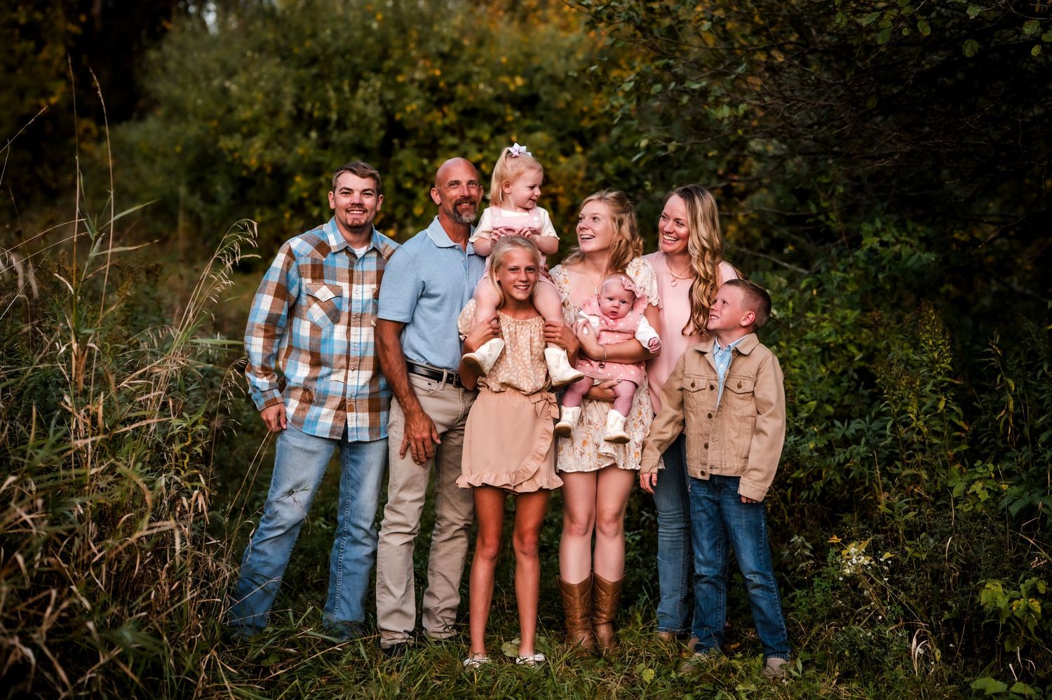 A group of people in coordinated outfits pose together outdoors for a series of family photos near Kewaskum, WI