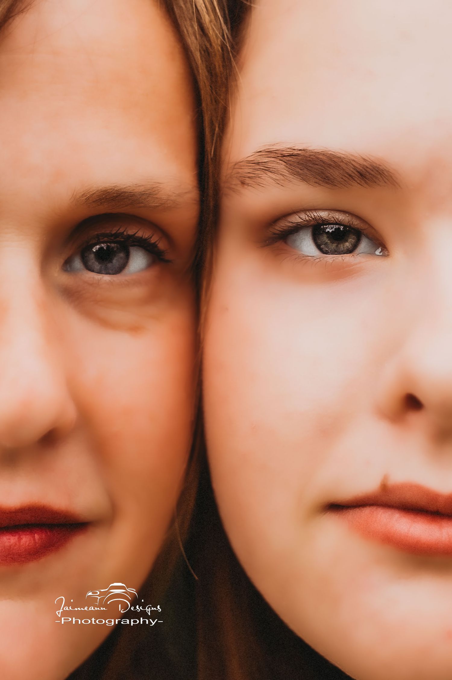 Close up beauty portrait showing two faces with dramatic lighting and makeup against neutral background.