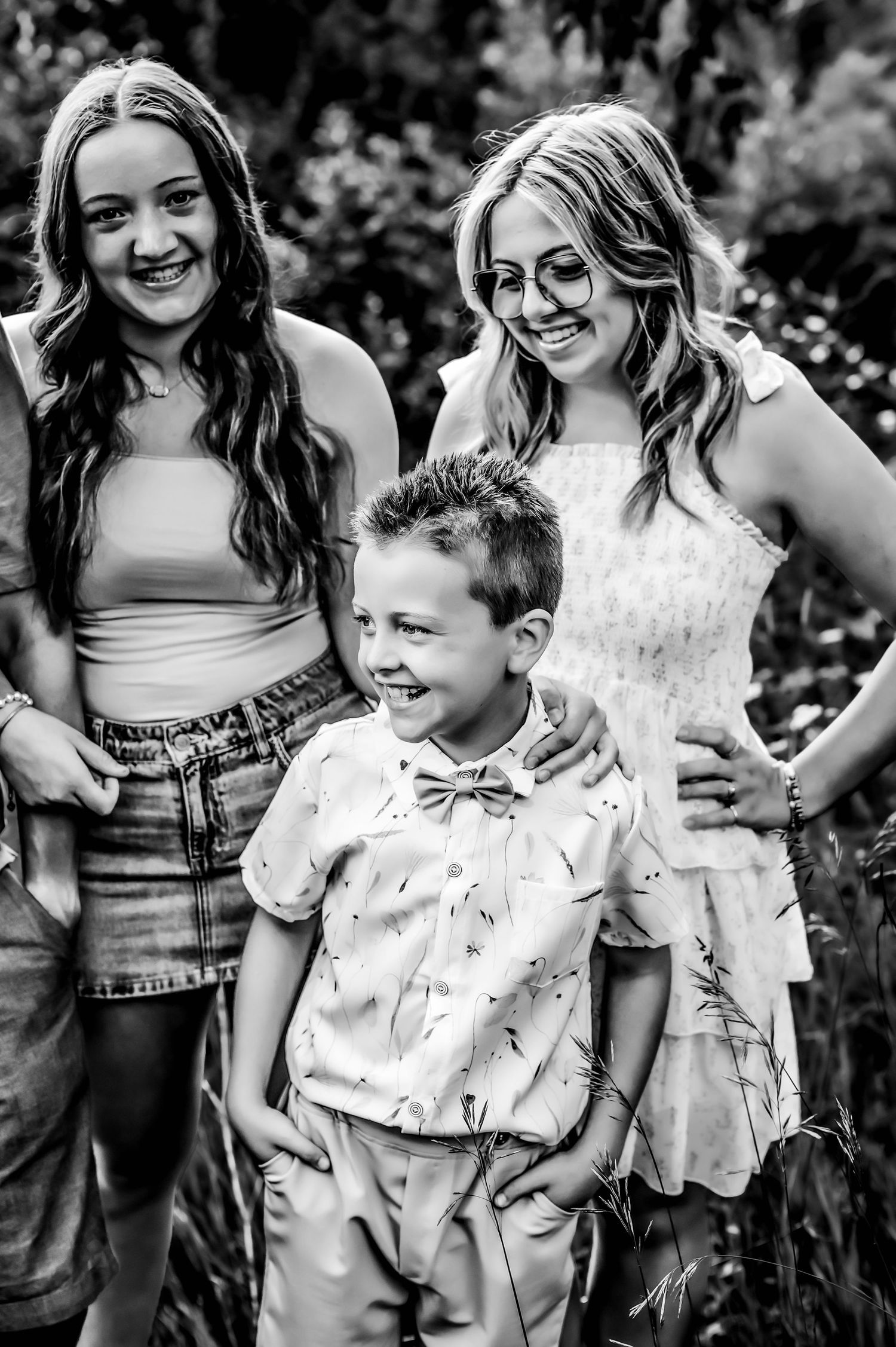 Black and white candid photo series showing joyful interaction between siblings in an outdoor setting at Little Cedar Lake, West Bend, WI