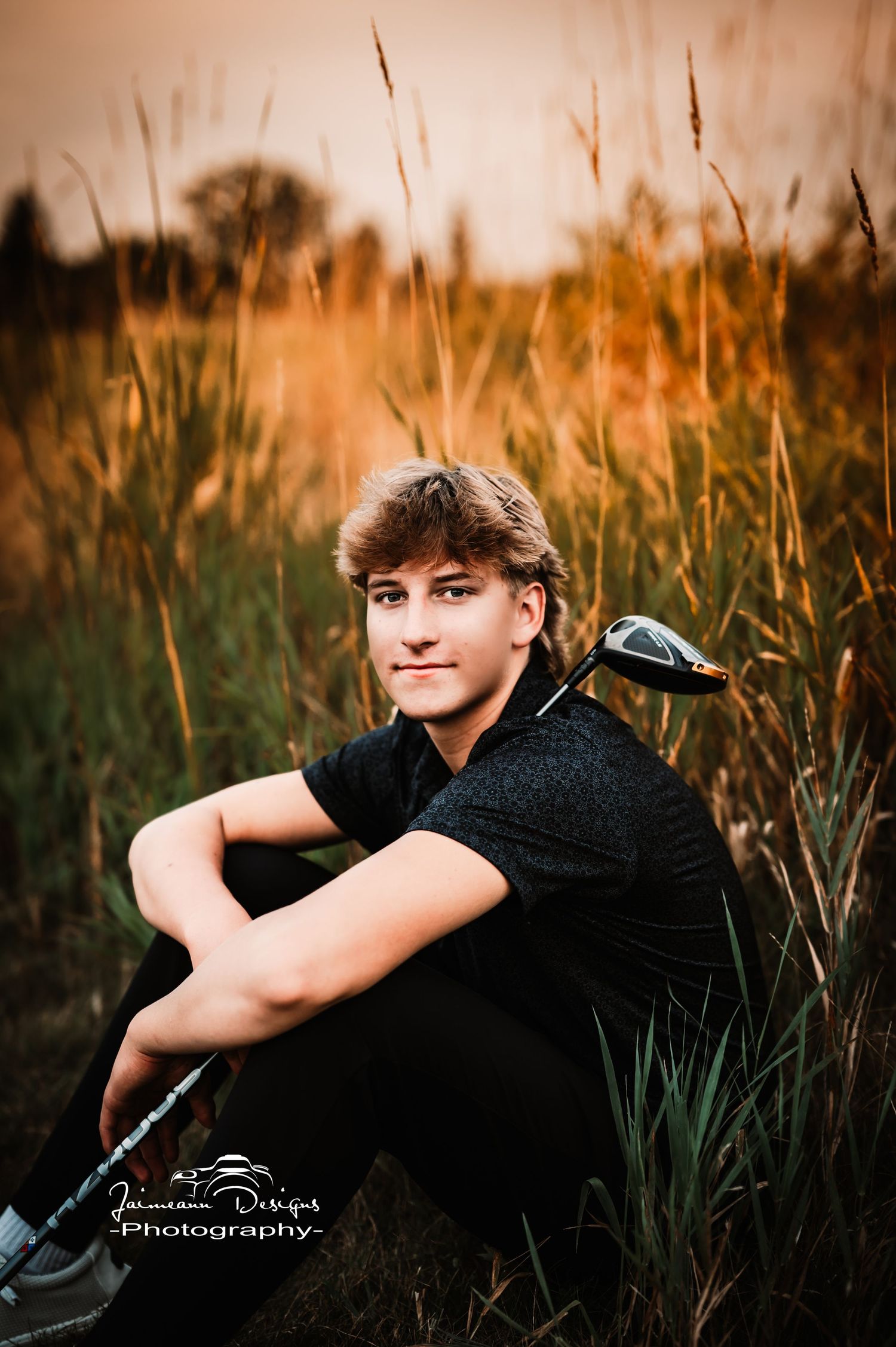 Portrait of a golfer sitting in tall grass during golden hour.