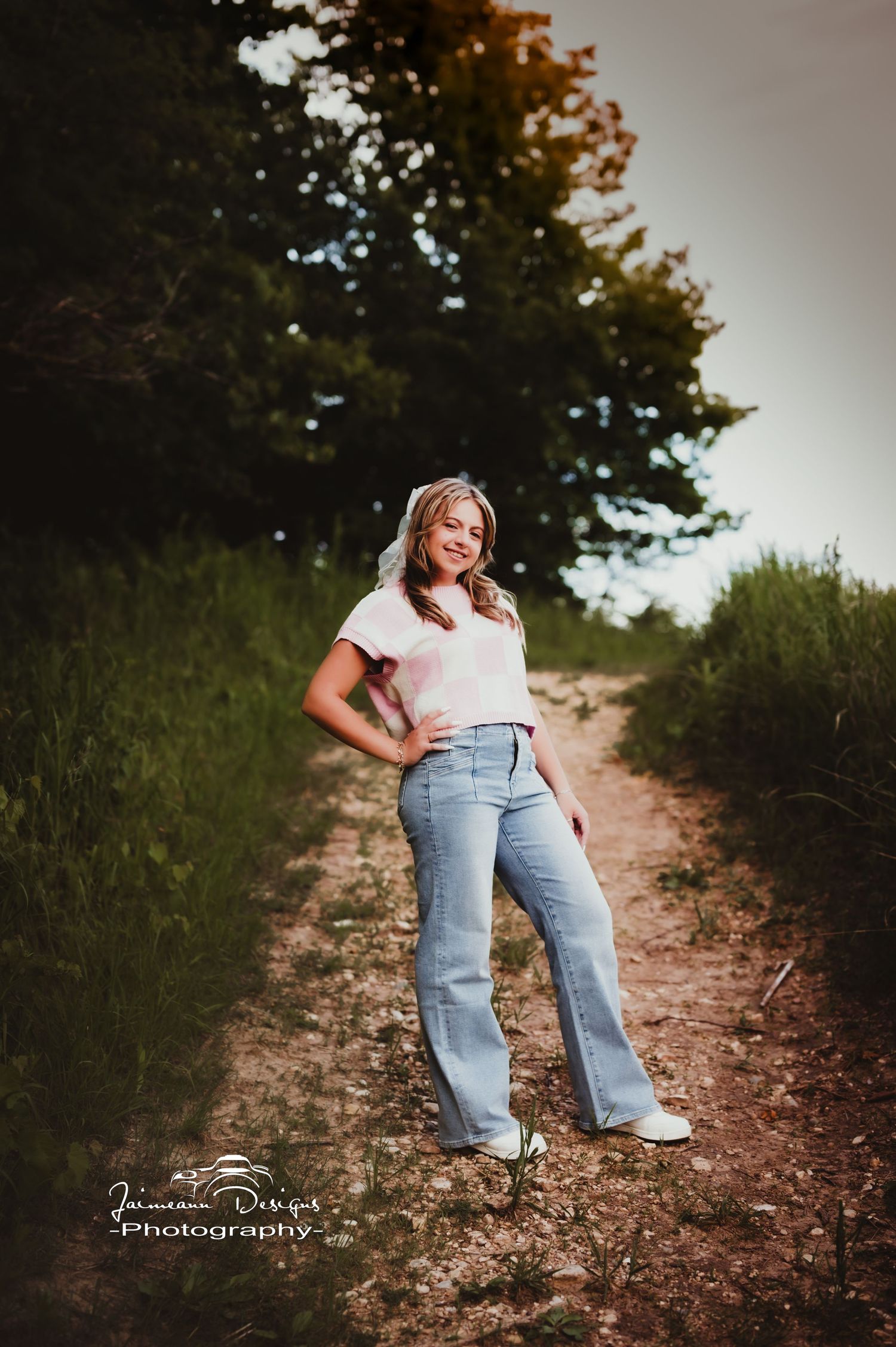 Standing on a dirt path wearing retro flared jeans and white t-shirt.