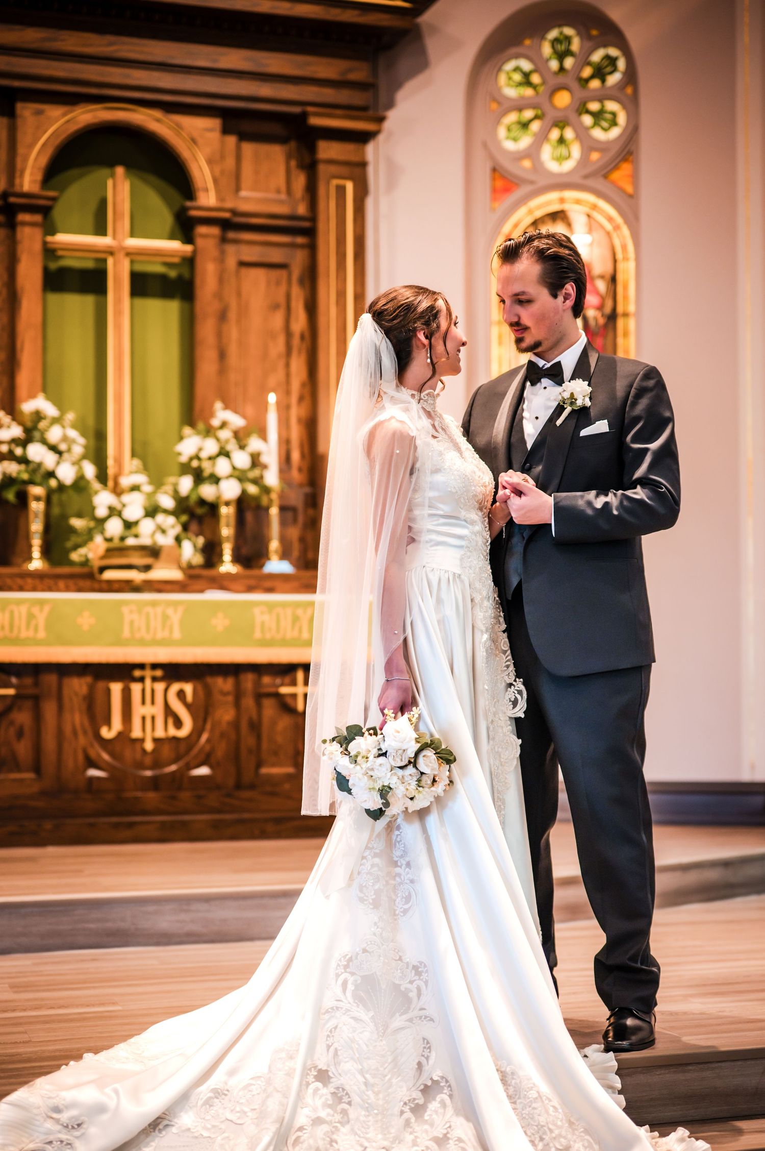 Traditional church wedding ceremony with elegant white dress and classic black tuxedo.