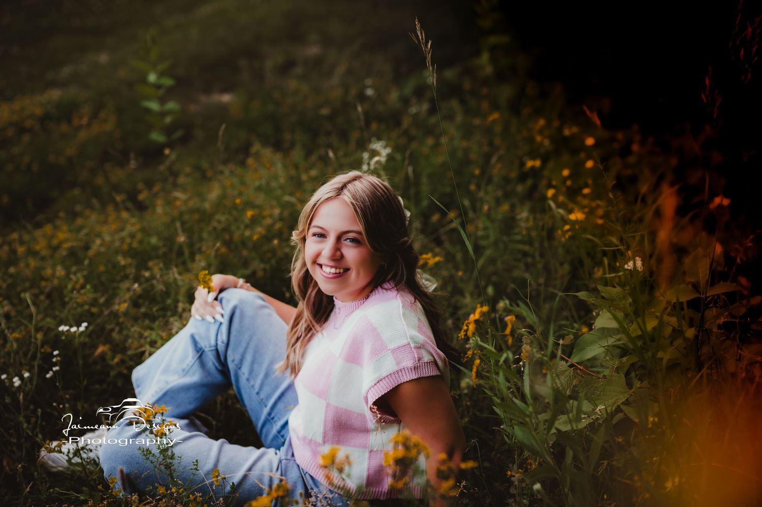 Relaxed outdoor portrait among wildflowers with warm lighting effects.