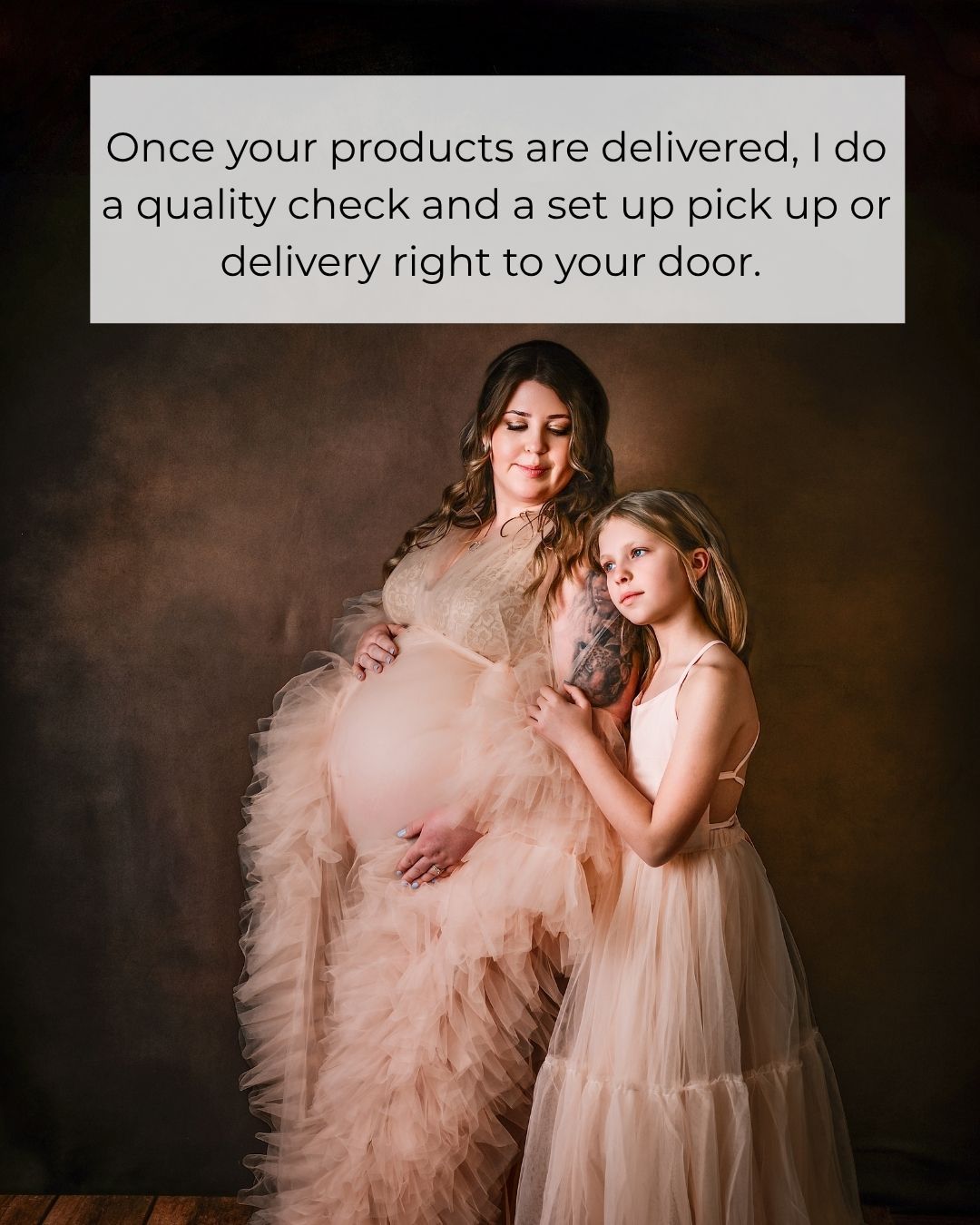 Pregnant woman in blush tulle gown poses with young girl in matching dress for maternity photo session.