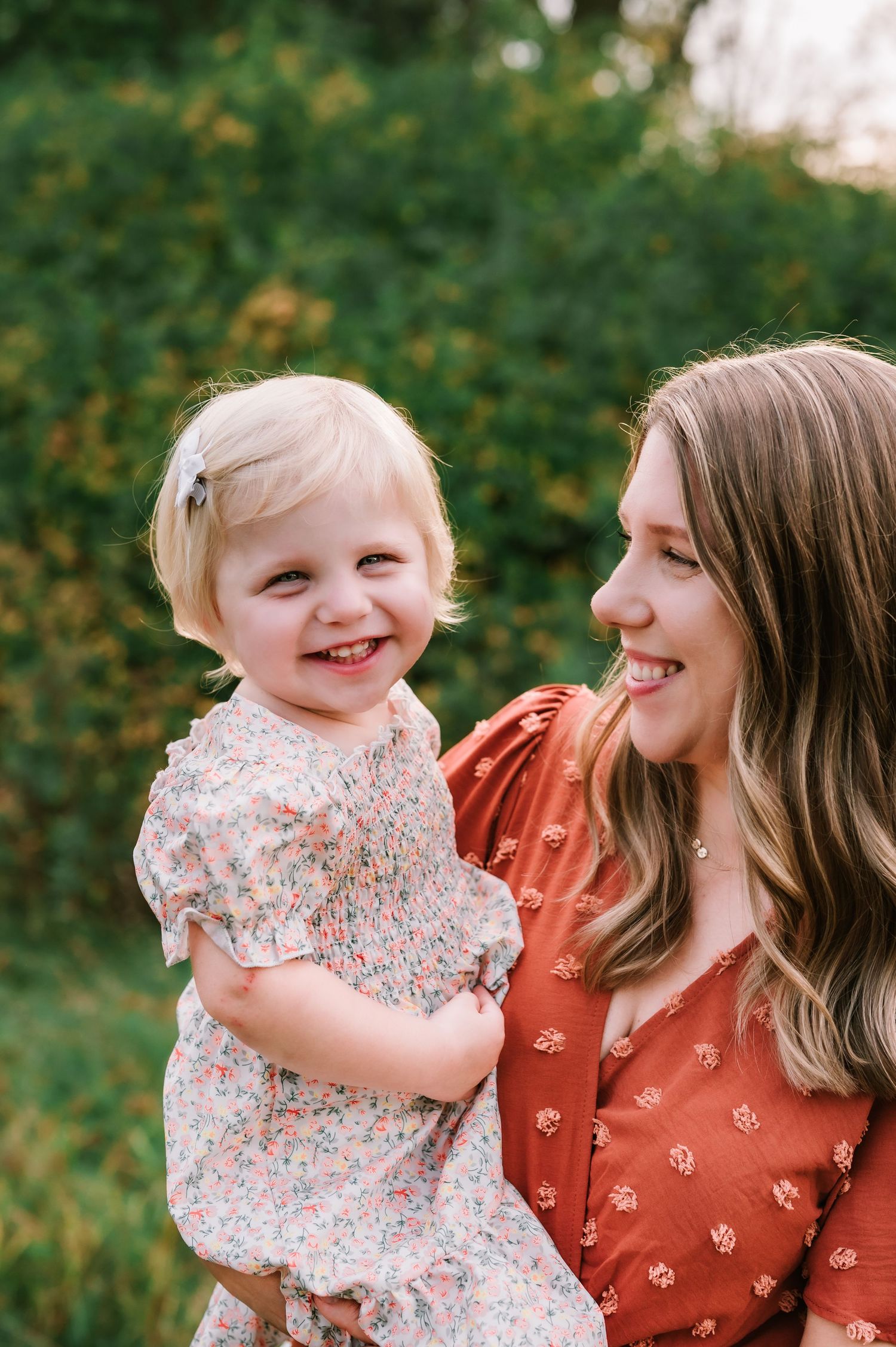A heartwarming moment captured in nature as a parent and child share joyful laughter together.
