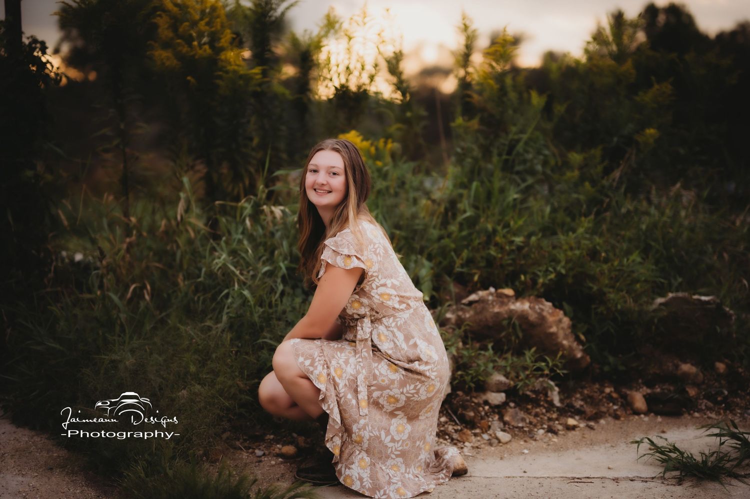 A floral dress creates a romantic silhouette against the natural sunset scenery.
