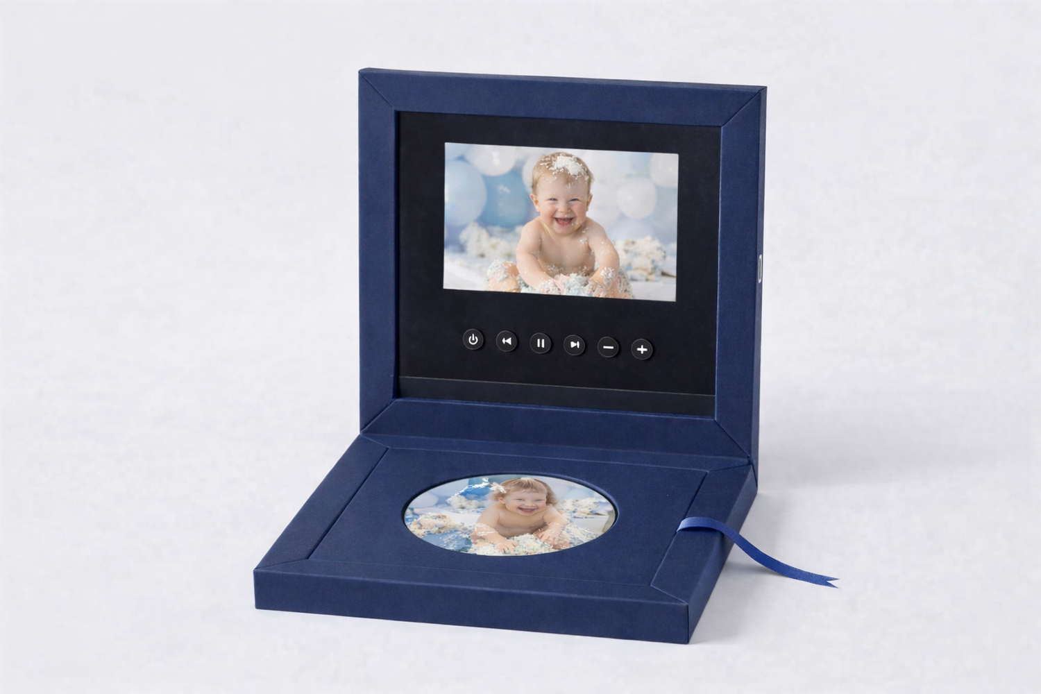 Navy blue video greeting card box with LCD screen and circular photo insert featuring a smiling baby portrait.