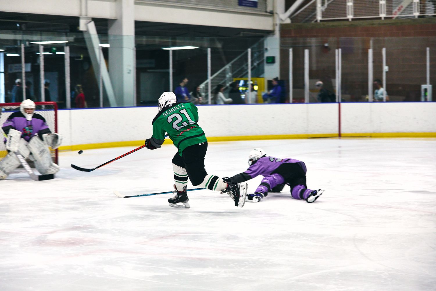 Adult hockey player taking a slapshot during a beer league game in Provo, Utah