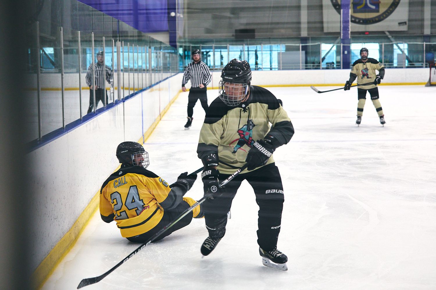 Adult hockey players battling for the puck along the boards