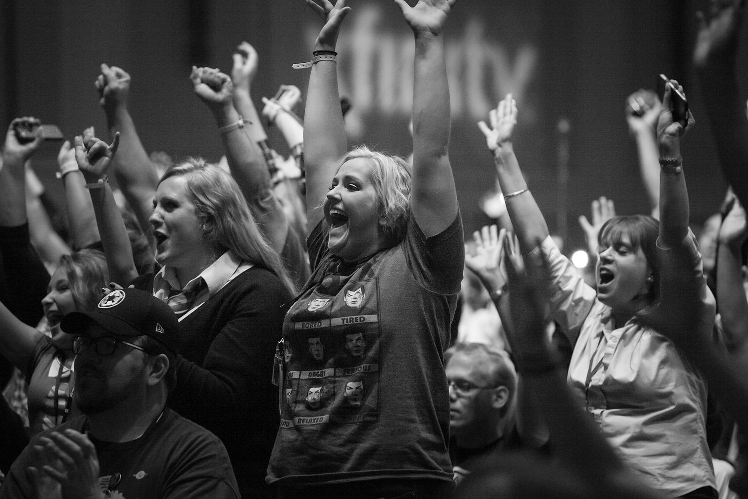 Black and White of fans screaming and raising their arms in excitement at a comic convention