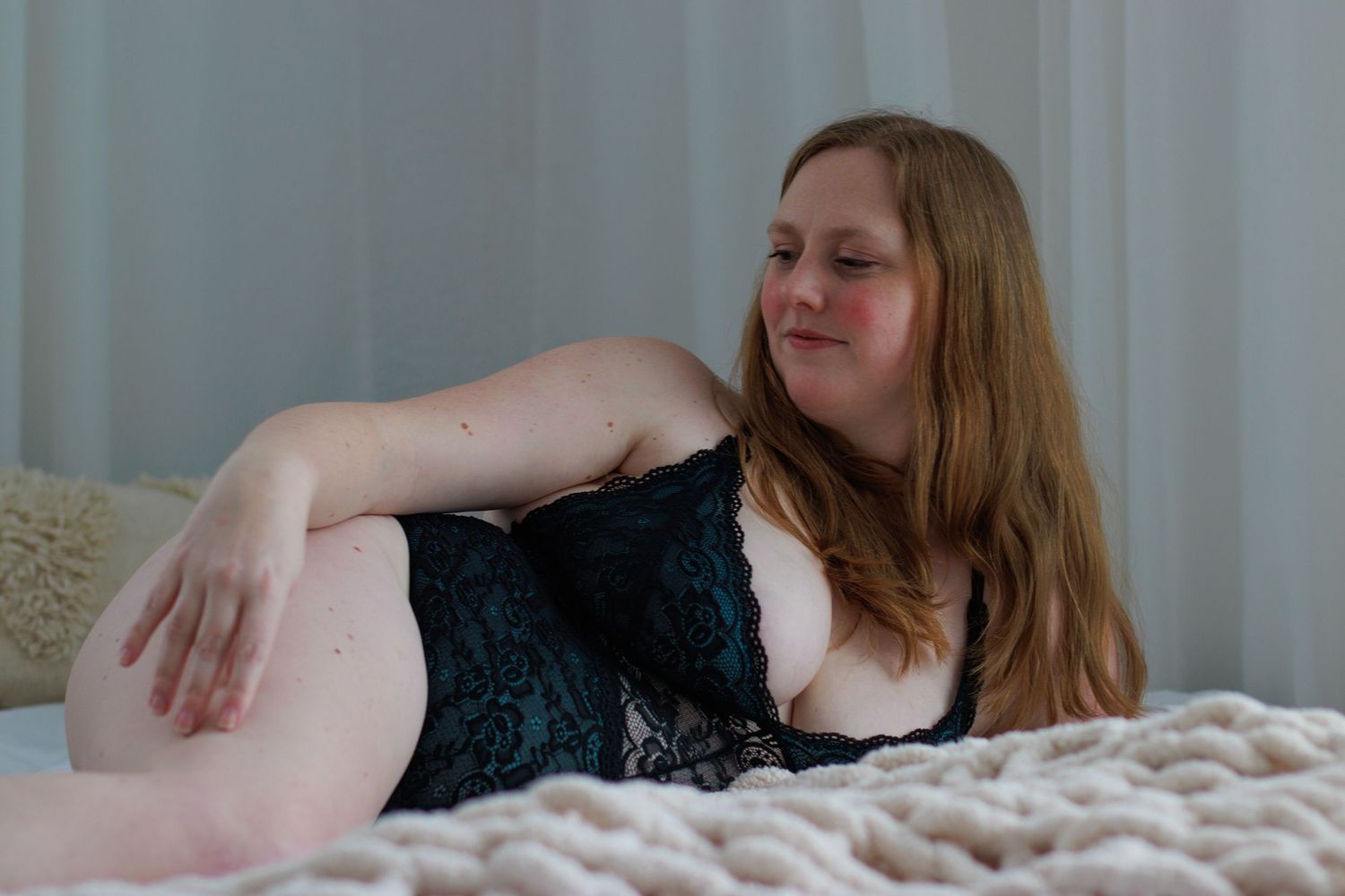 Woman in lingerie lying on bed