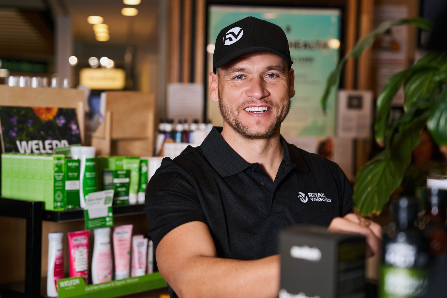 Sydney pharmacy staff in black polo shirts work behind the counter at a modern wellness store- Business photography content for website.
