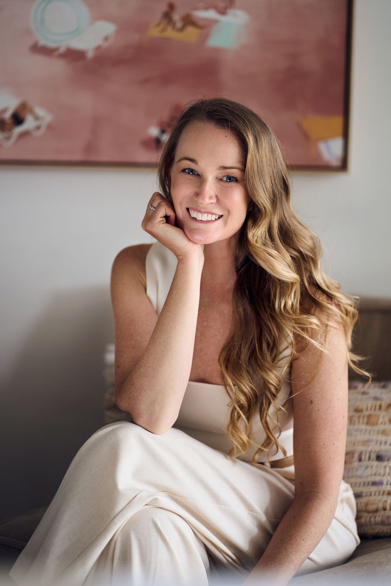 Woman in white dress lounges on couch in artistic portrait series by Studio TingTing.