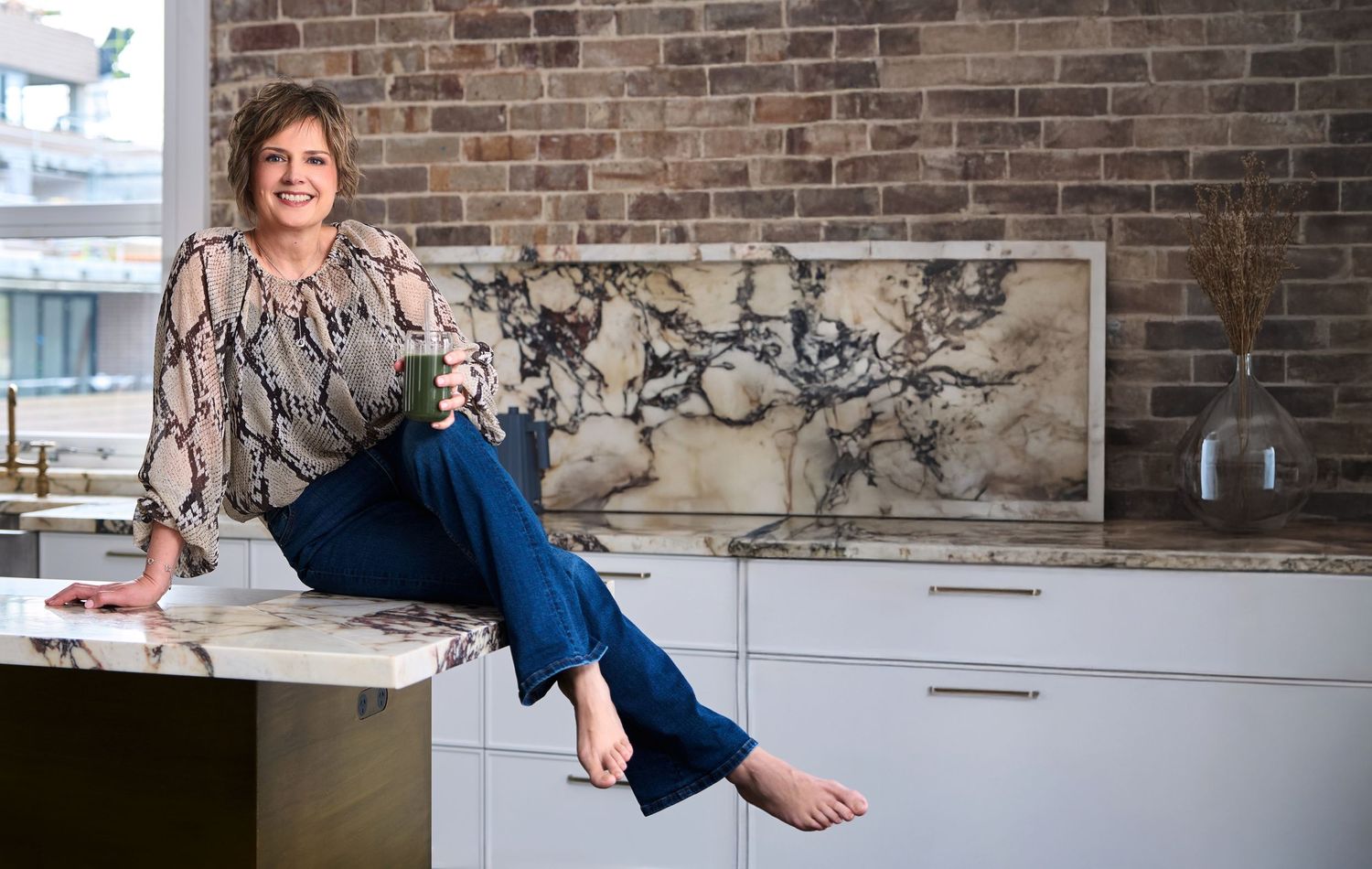 A casual professional photo of a sydney nutritionist posing in a modern kitchen shot by Studio TingTing.