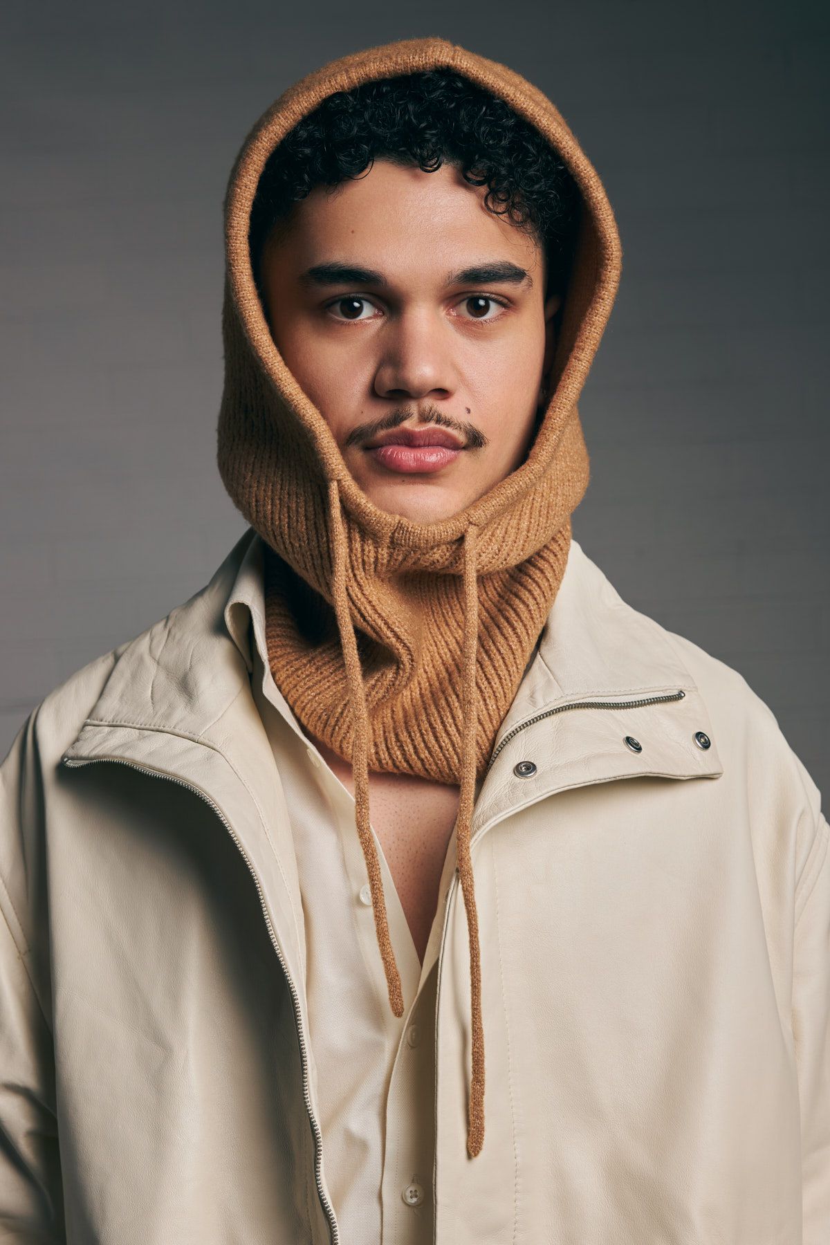 Portrait of a model wearing a tan hooded sweatshirt and light beige jacket for a fashion brand in Sydney by Studio TingTing.