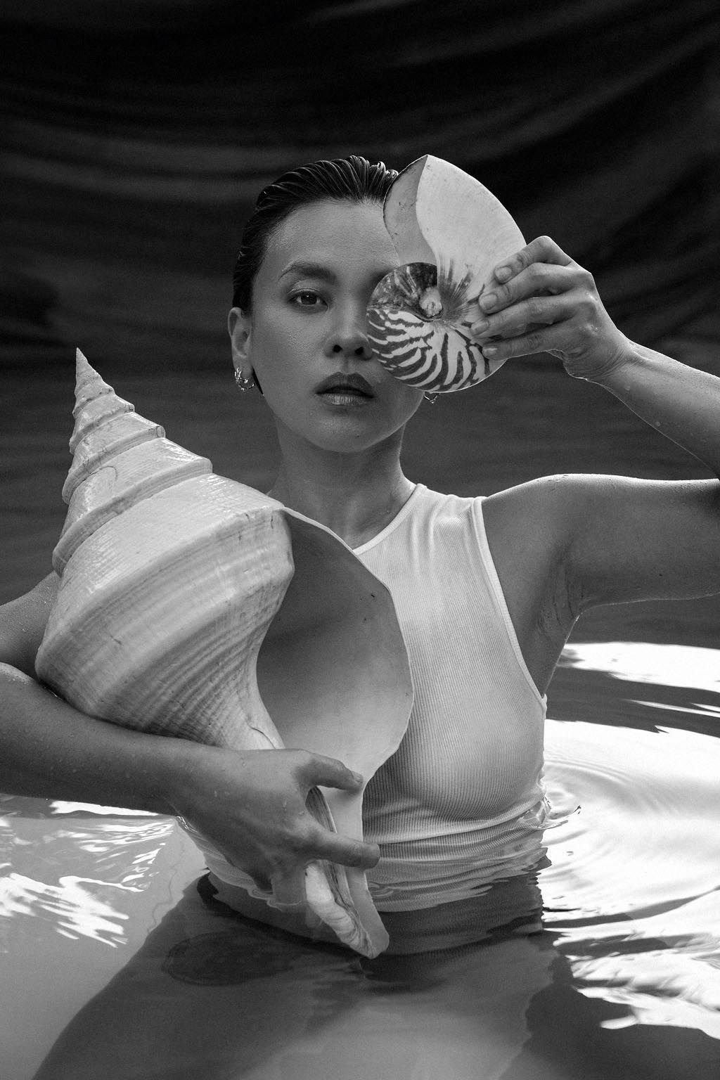 Artistic black and white water photography with seashell props.