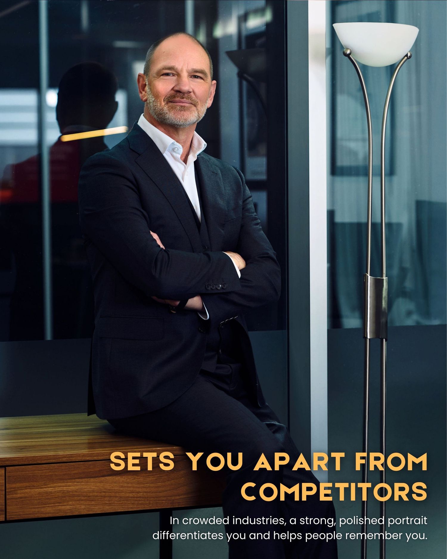 Professional business portrait showing a man in a dark suit against a modern office setting with text and floor lamp by Studio TingTing.