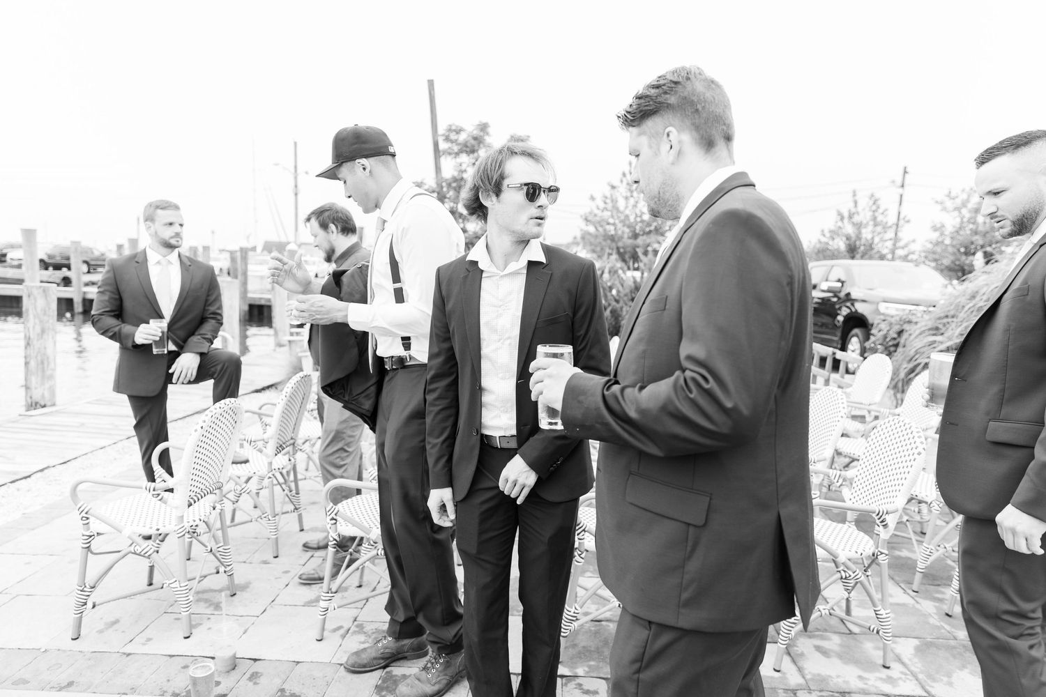 A group of people in formal attire gather outdoors examining a construction or building site together.