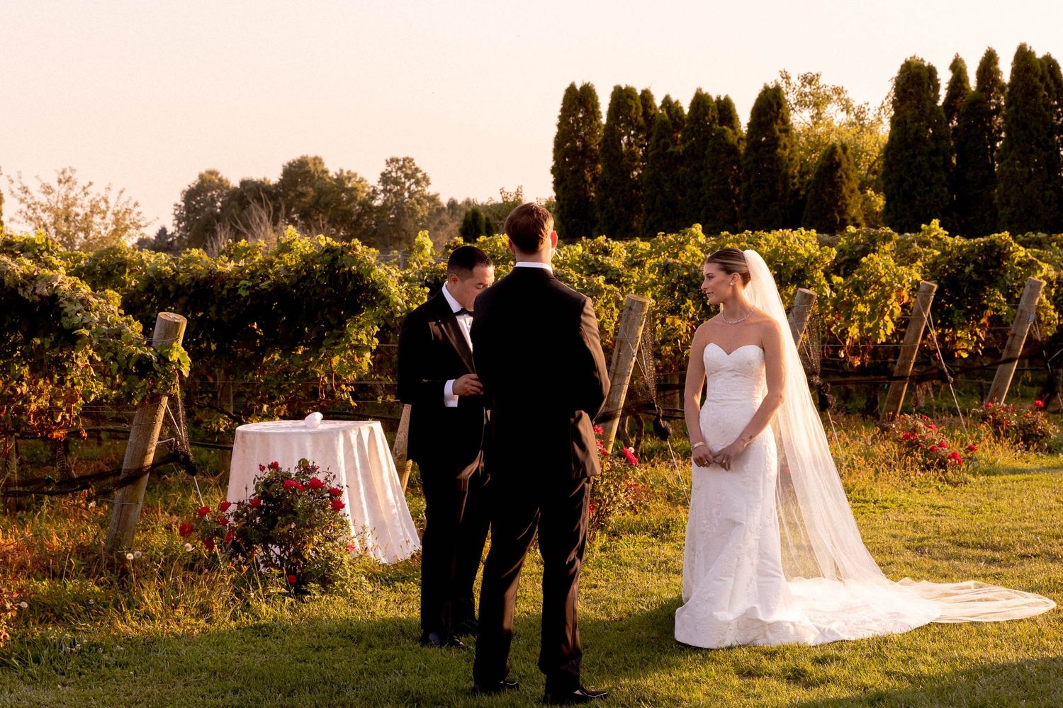 Golden hour wedding ceremony with guests watching the couple exchange vows in an outdoor setting.
