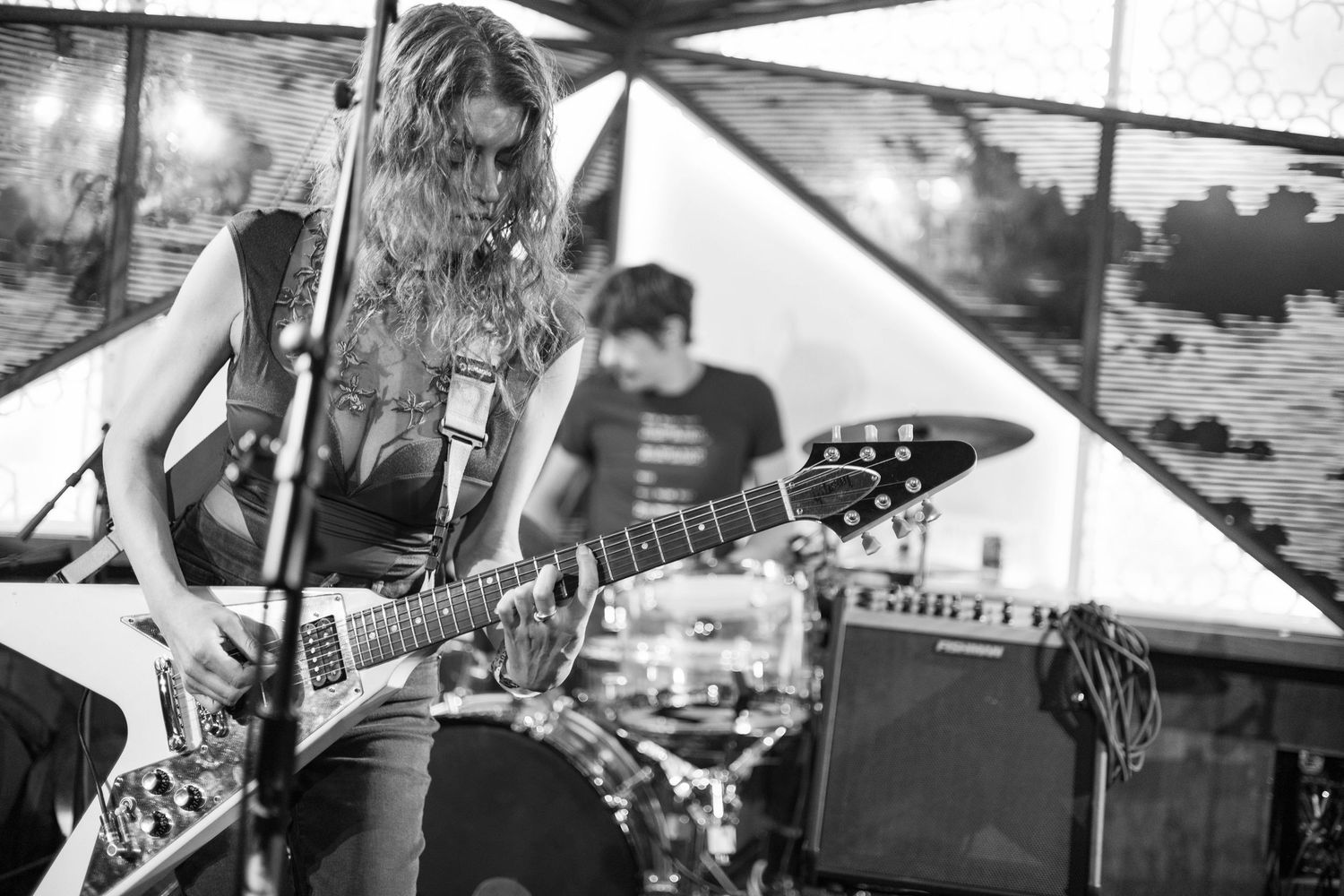 Musicians playing guitars and performing on stage during live concert.