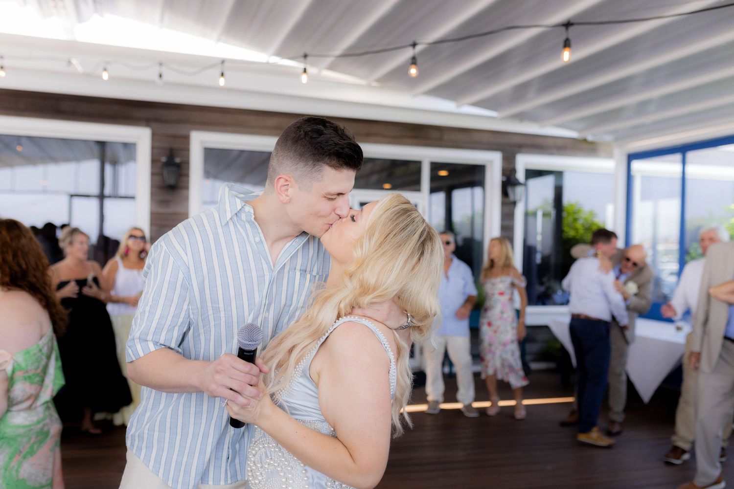 Couples dancing together in an elegant white-walled venue during a wedding celebration.