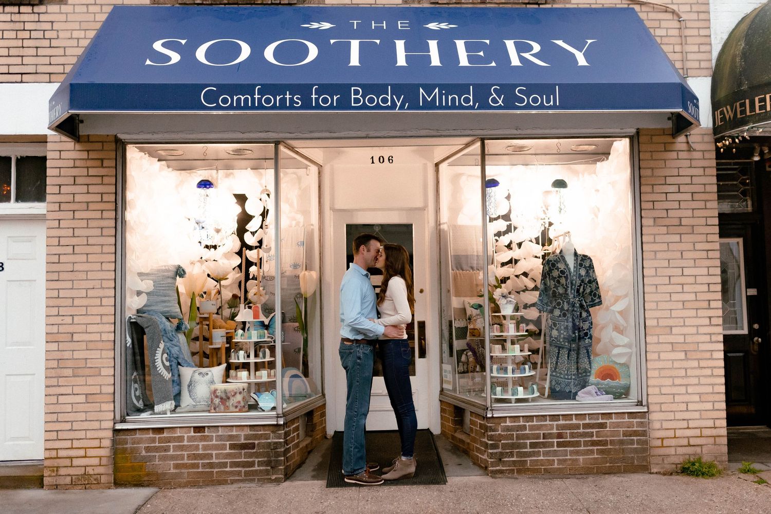 A storefront sign reading 'The Soothery' with 'Comforts for Body, Mind, & Soul' on a brick building.