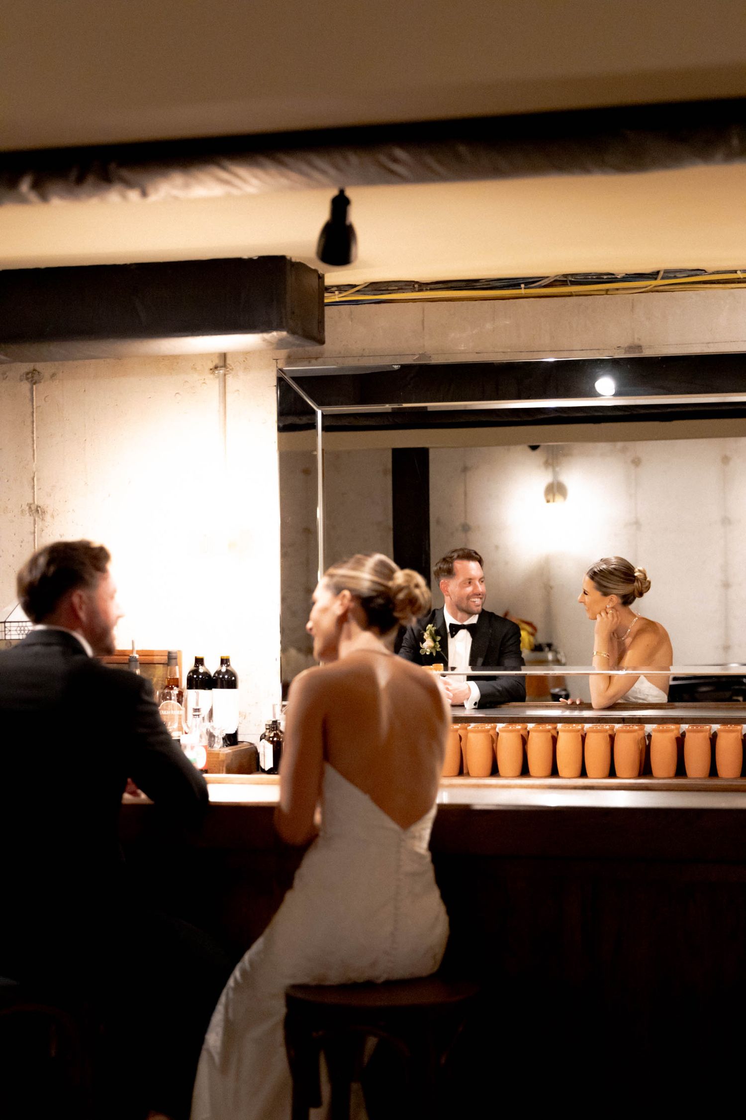 A series of blurred wedding reception photos showing guests dancing and mingling at a dimly lit indoor venue.