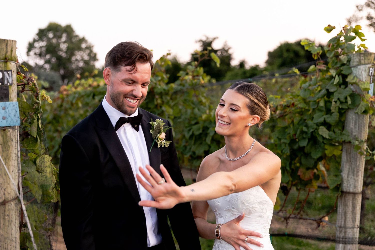Couple shares romantic moments among grapevines at sunset during their winery wedding photoshoot.