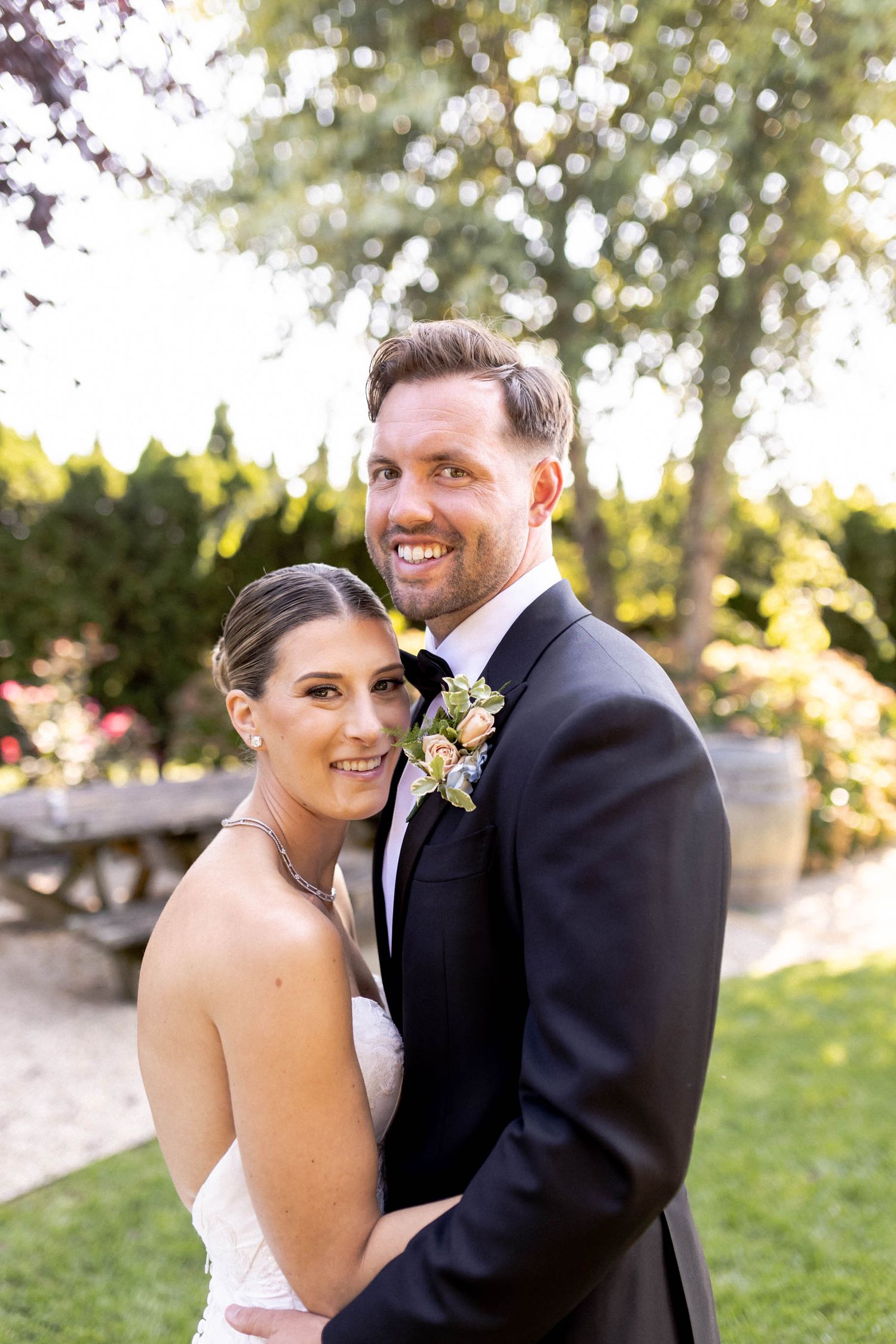 A romantic outdoor wedding photo series showing a couple embracing and smiling in a garden setting.