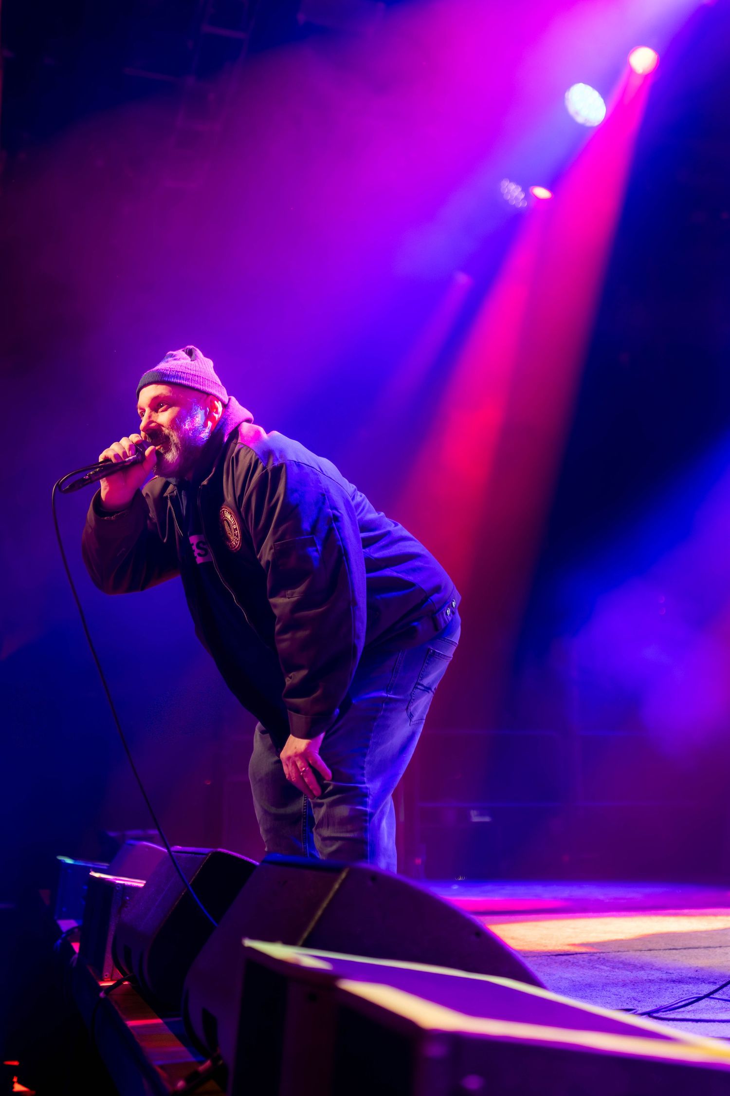 Dynamic stage performance captured under dramatic purple and red lighting effects.