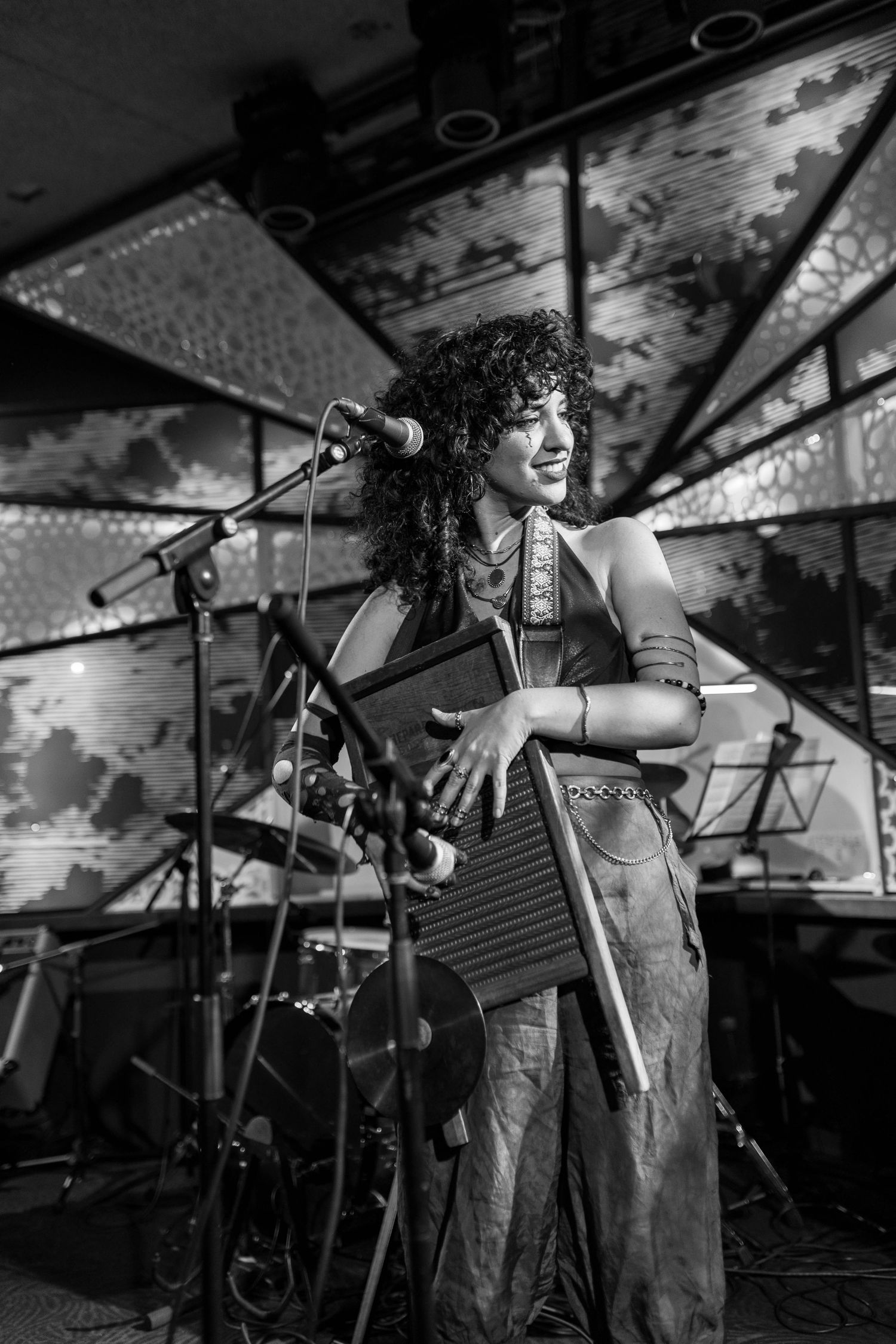 Musicians perform on stage with instruments during an energetic live performance in black and white.