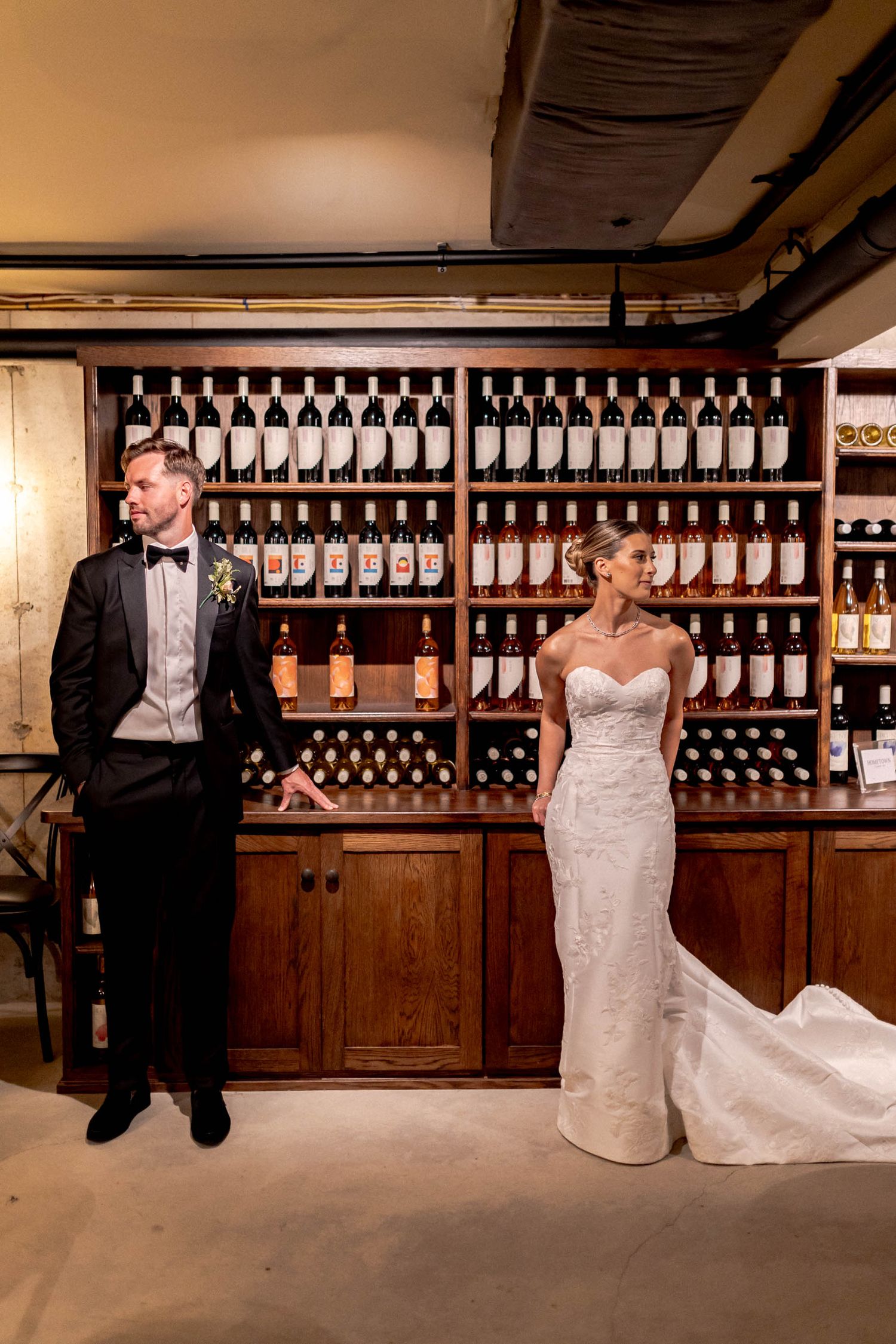 A romantic wedding photo sequence showing a couple in formal attire posing playfully in a rustic wine cellar.