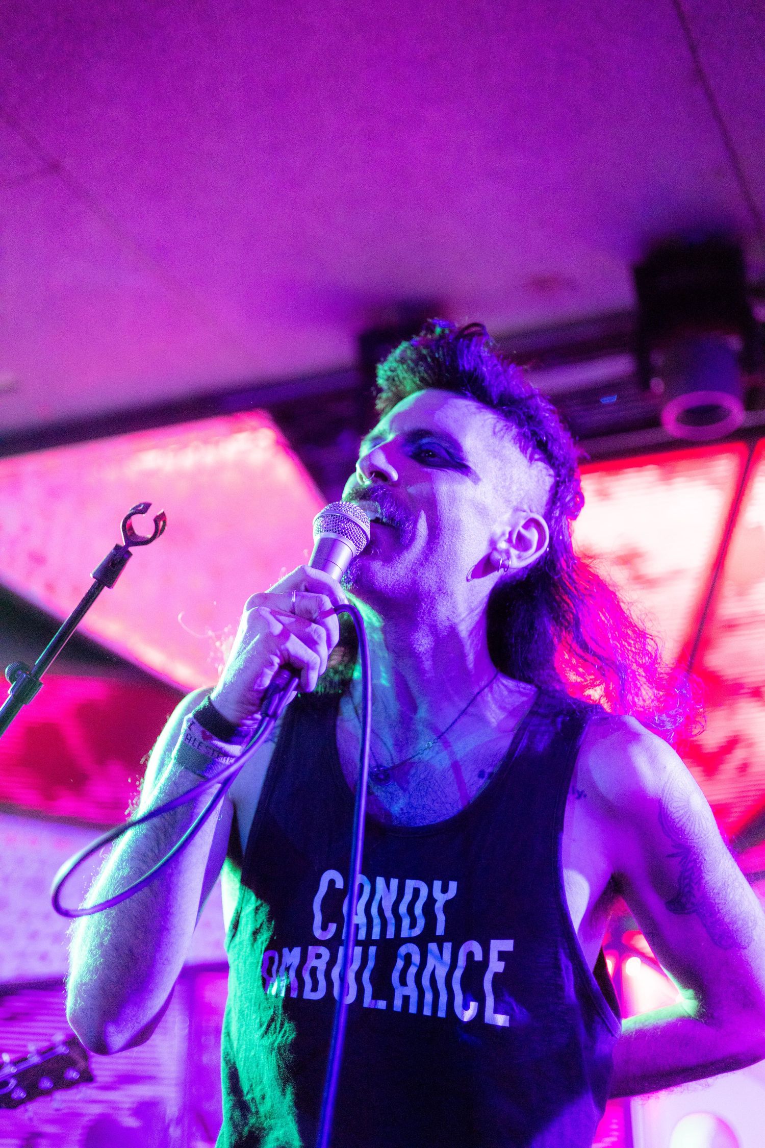 Concert performance lit with dramatic purple and red stage lighting effects.