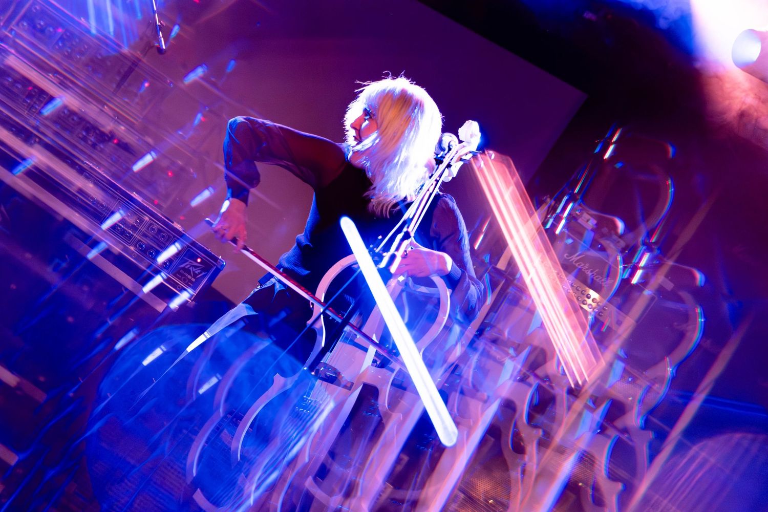 Abstract view of concert lighting equipment creating blue and purple patterns.