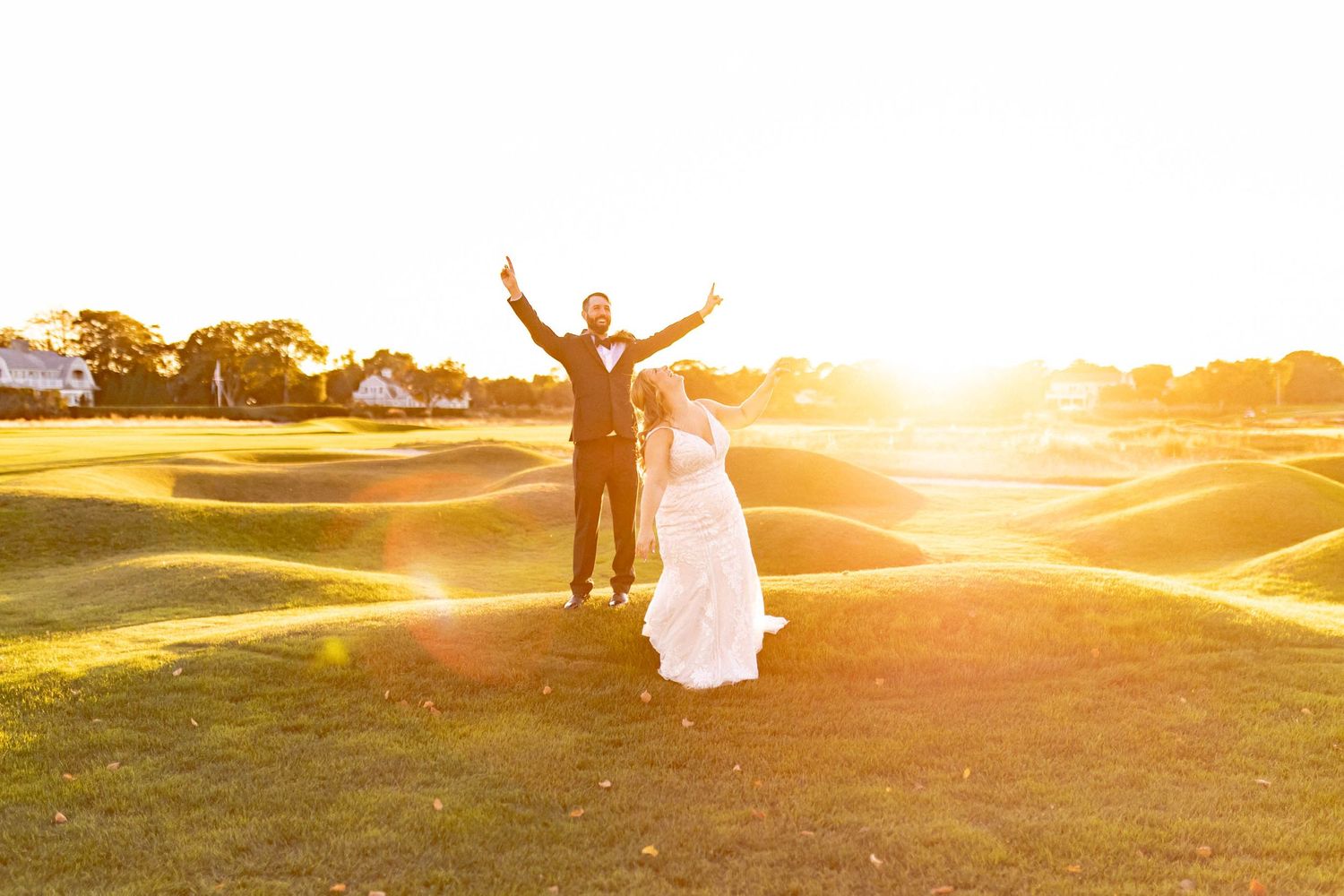 Silhouettes of a couple celebrating at sunset in a field with dramatic golden light.