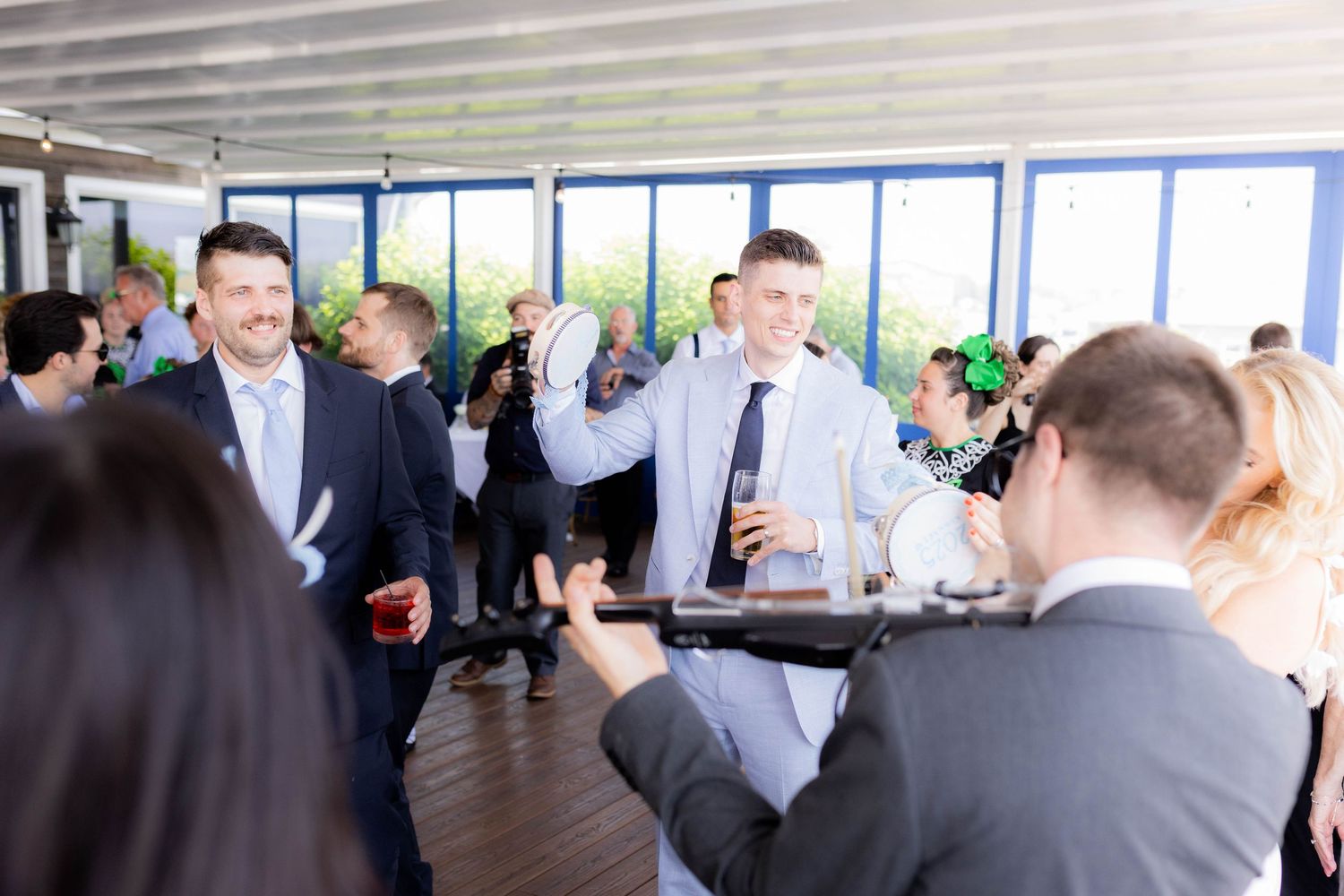 People mingling at a business networking event in a bright modern office space with large windows.
