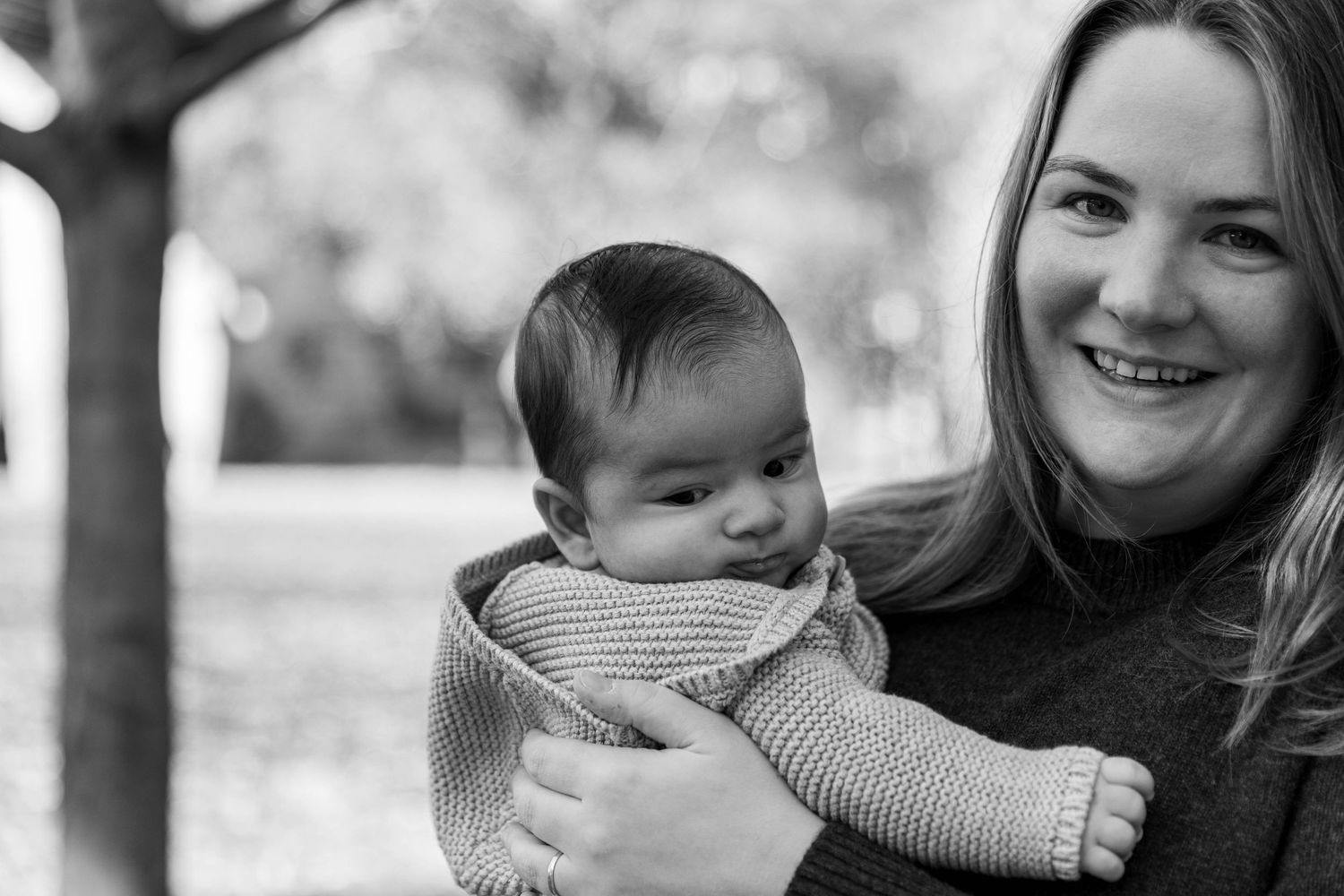 Black and white portrait of family members sharing intimate moment outdoors.