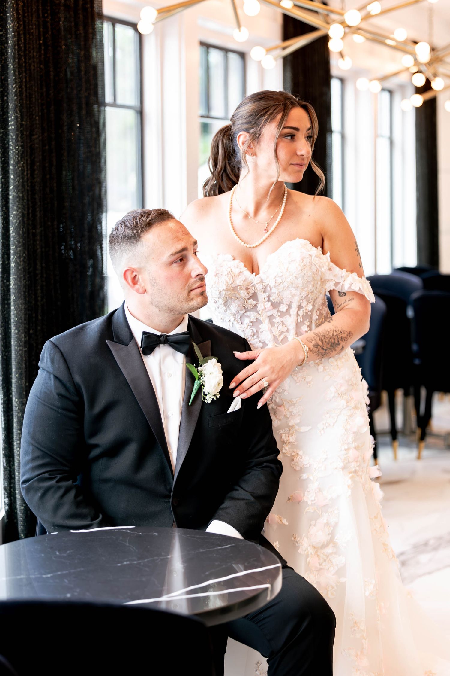An elegant wedding portrait featuring formal attire and a stunning lace gown.