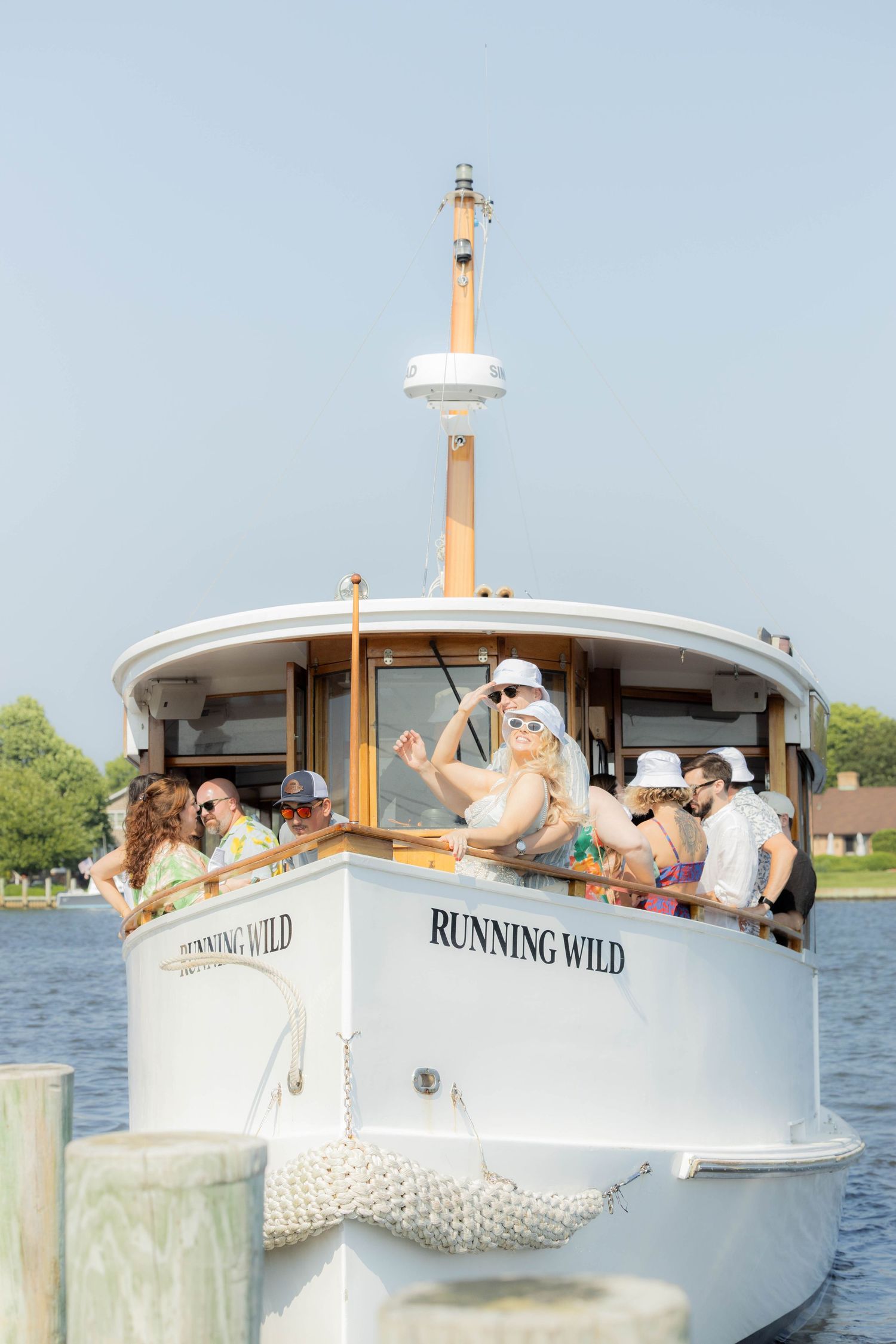 Luxury boat Running Wild with passengers enjoying a leisure cruise on a peaceful lake.