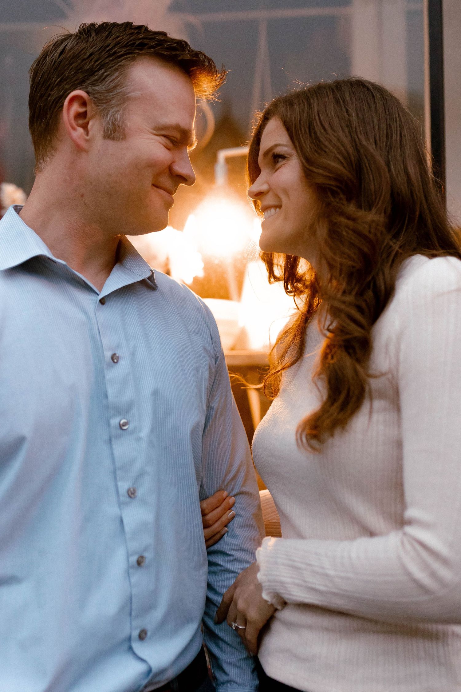 An intimate couple's portrait session at night with warm glowing lights creating a romantic ambiance.