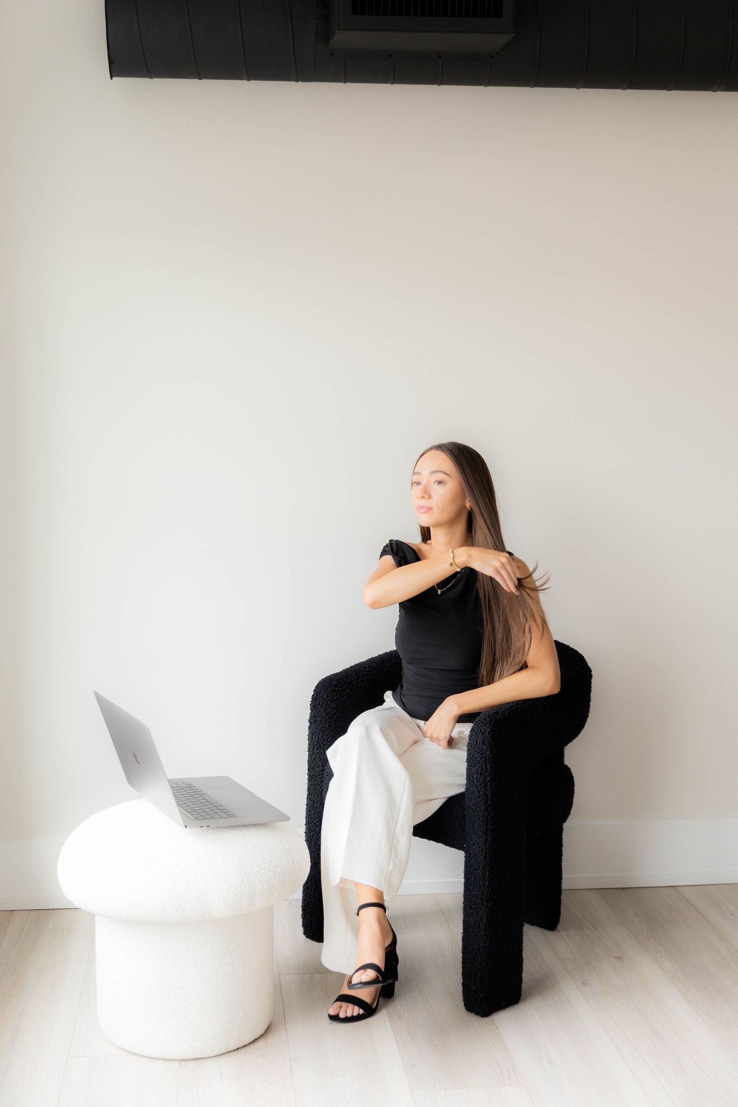 Minimalist photo series showing a person in black and white clothing posing with modern furniture.