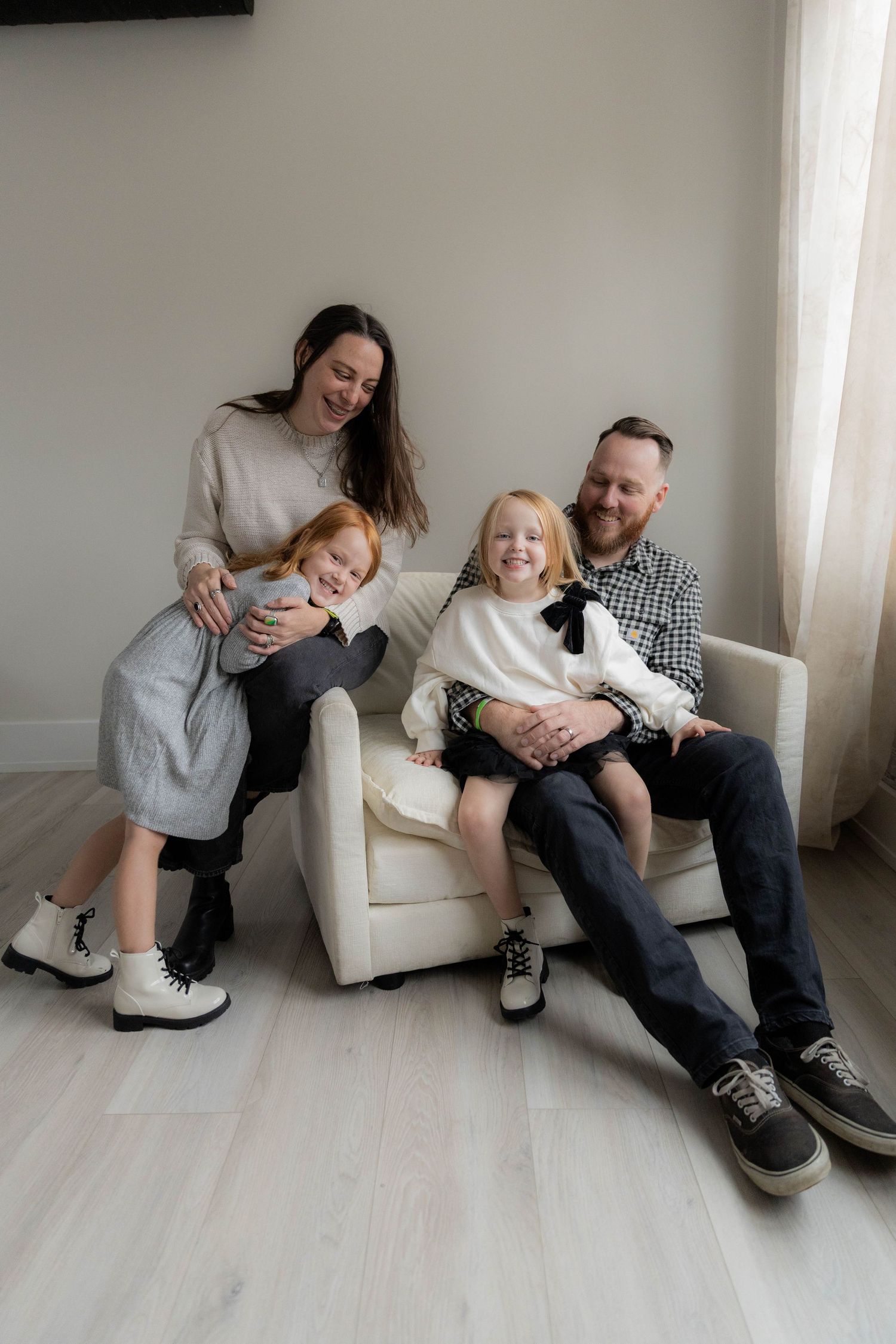 Candid moments of family bonding on a white armchair in a minimalist room. Huntington Loft. Fireside Sparrow Photography
