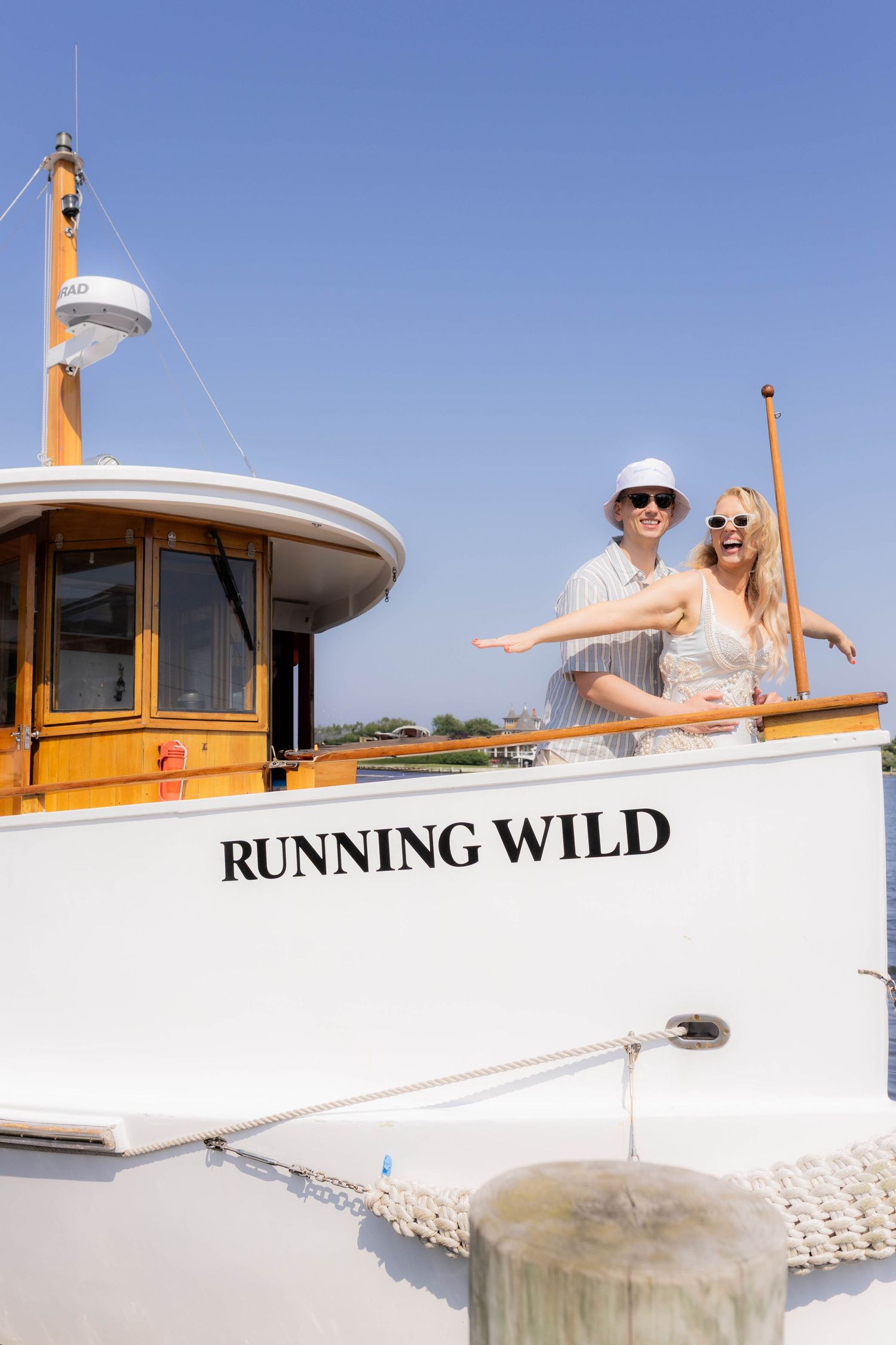 A boat named 'Running Wild' with passengers enjoying a sunny day on the water.