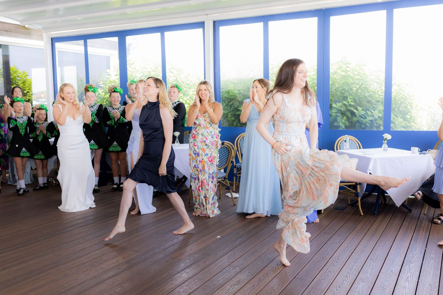 Irish dancers perform traditional steps in synchronized formation on a wooden deck during a celebration.