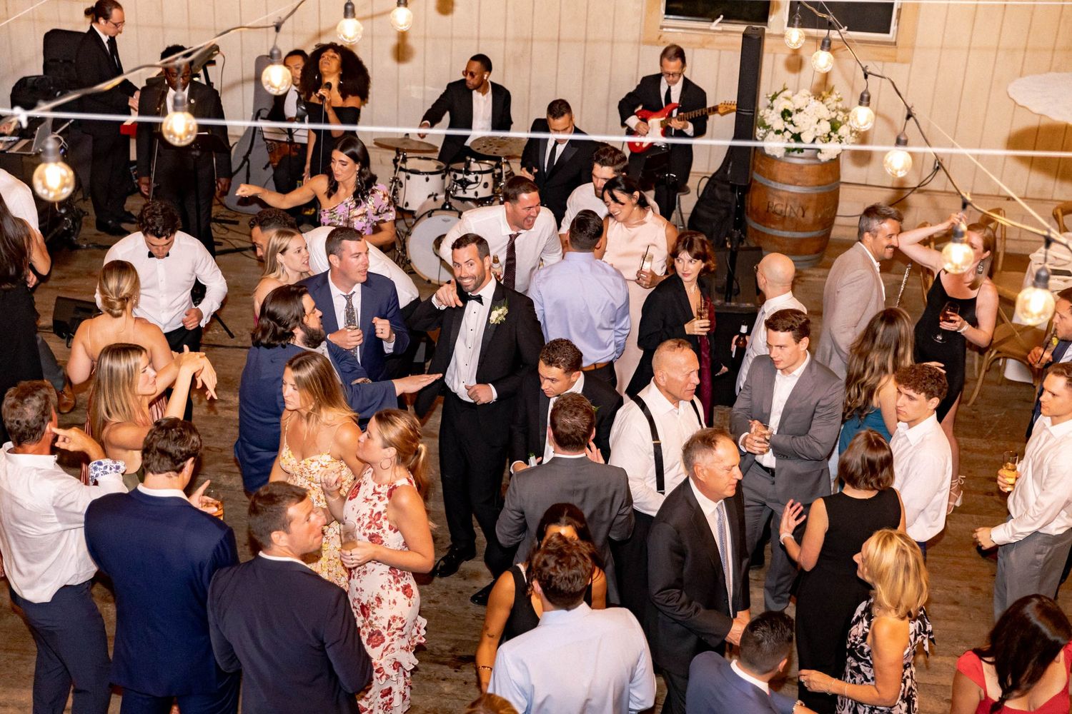 A crowded wedding reception venue filled with guests mingling and socializing in an elegant indoor setting.