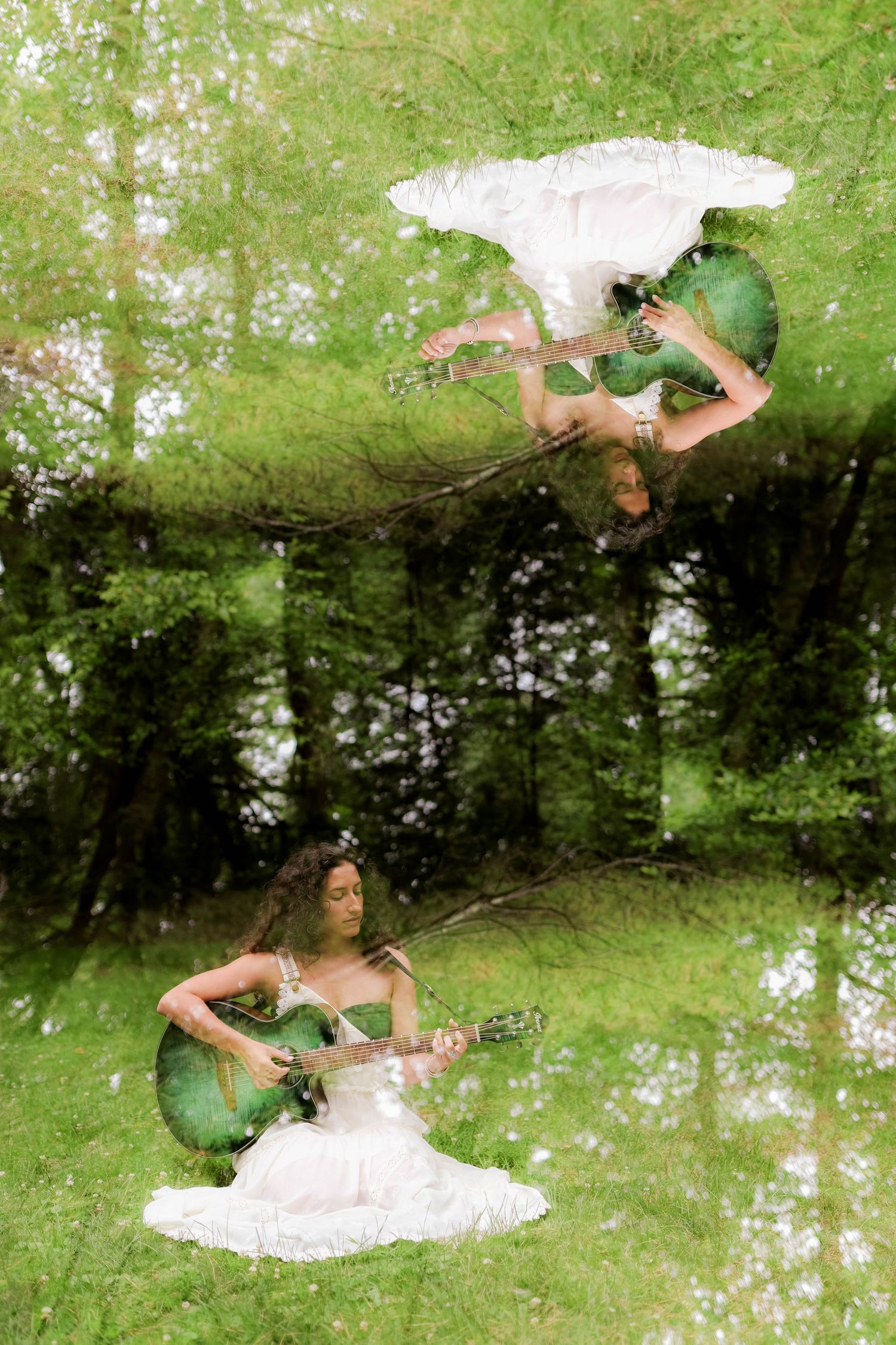 Double exposure photo of guitarist in white dress against dreamy forest background.