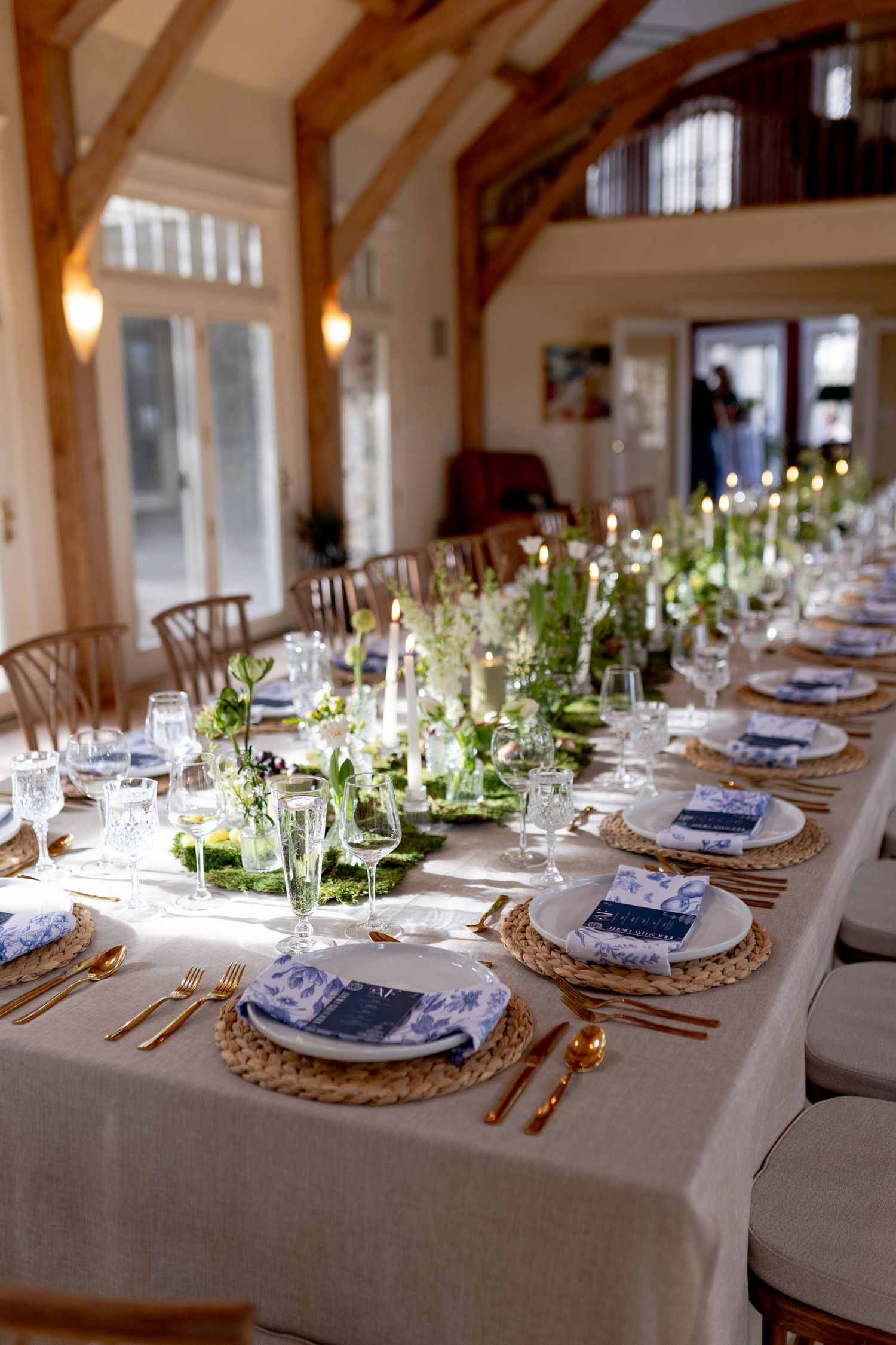 Elegant table settings with navy accents and woven chargers in rustic wooden venue.