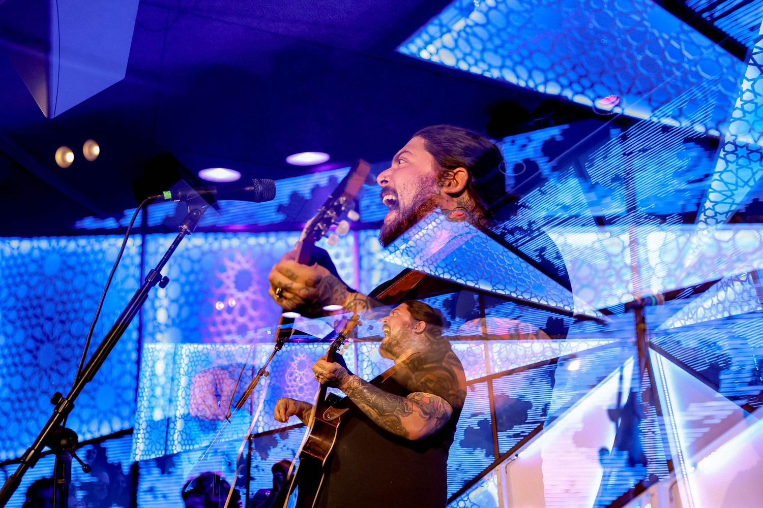 Musicians perform under blue stage lighting with textured backdrop during live show. Amigo the Devil in Brooklyn by Fireside Sparrow