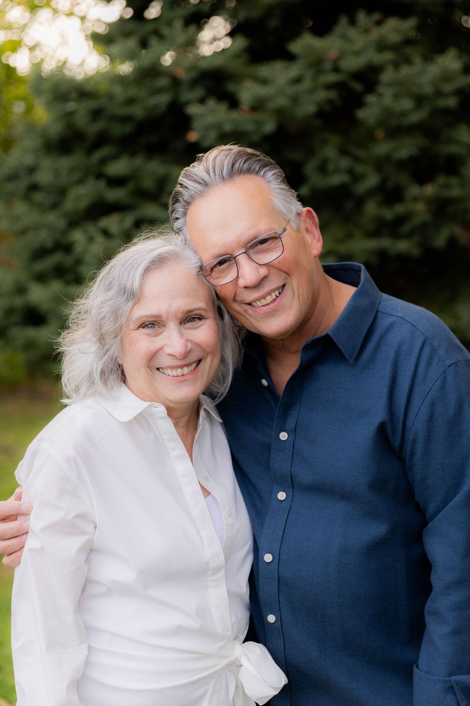 Couple shares intimate moment during outdoor portrait session in park setting.