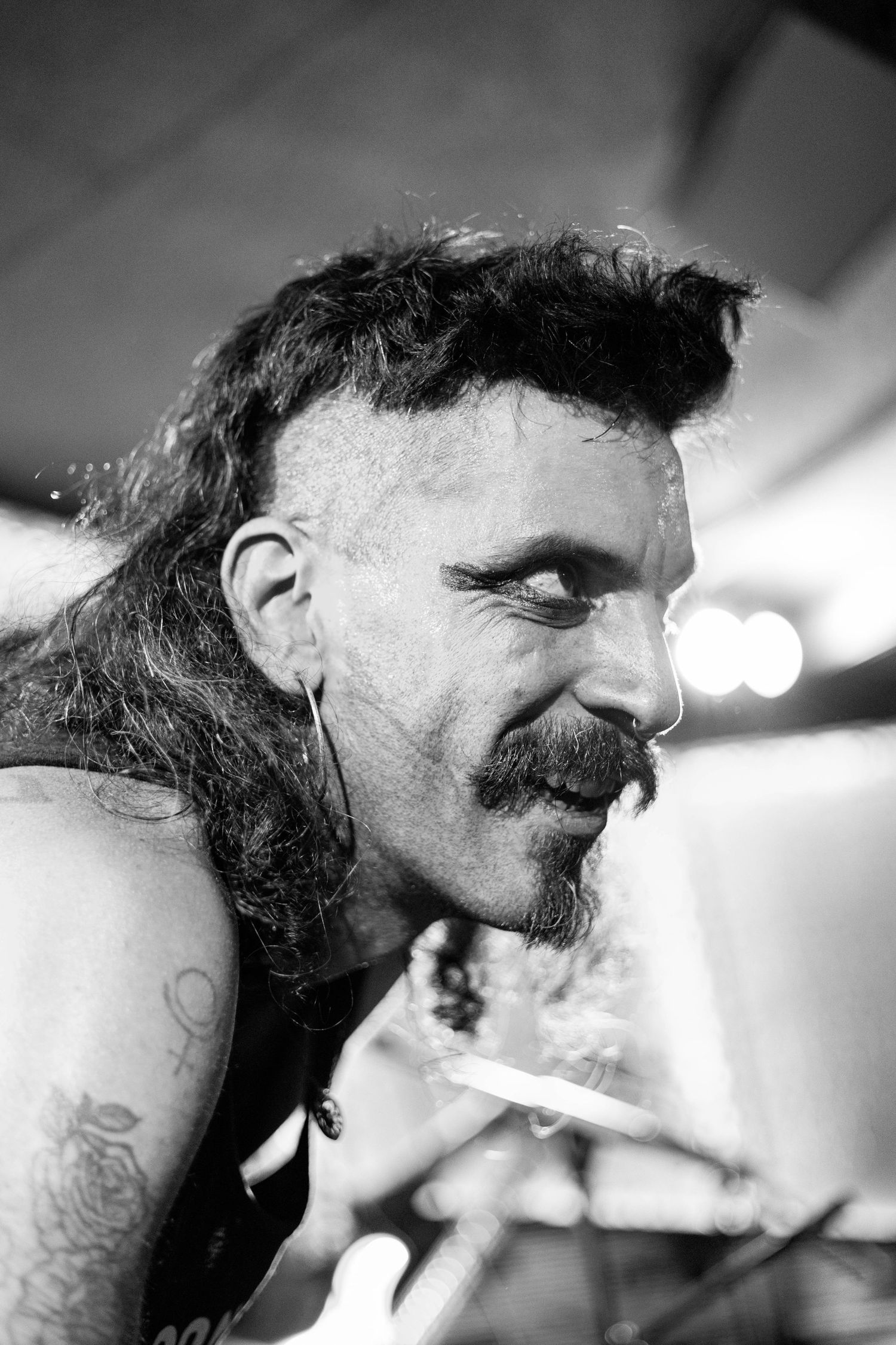 Close-up black and white profile shot of performer on stage with dramatic lighting. Brooklyn, the Sultan's Room by Fireside Sparrow